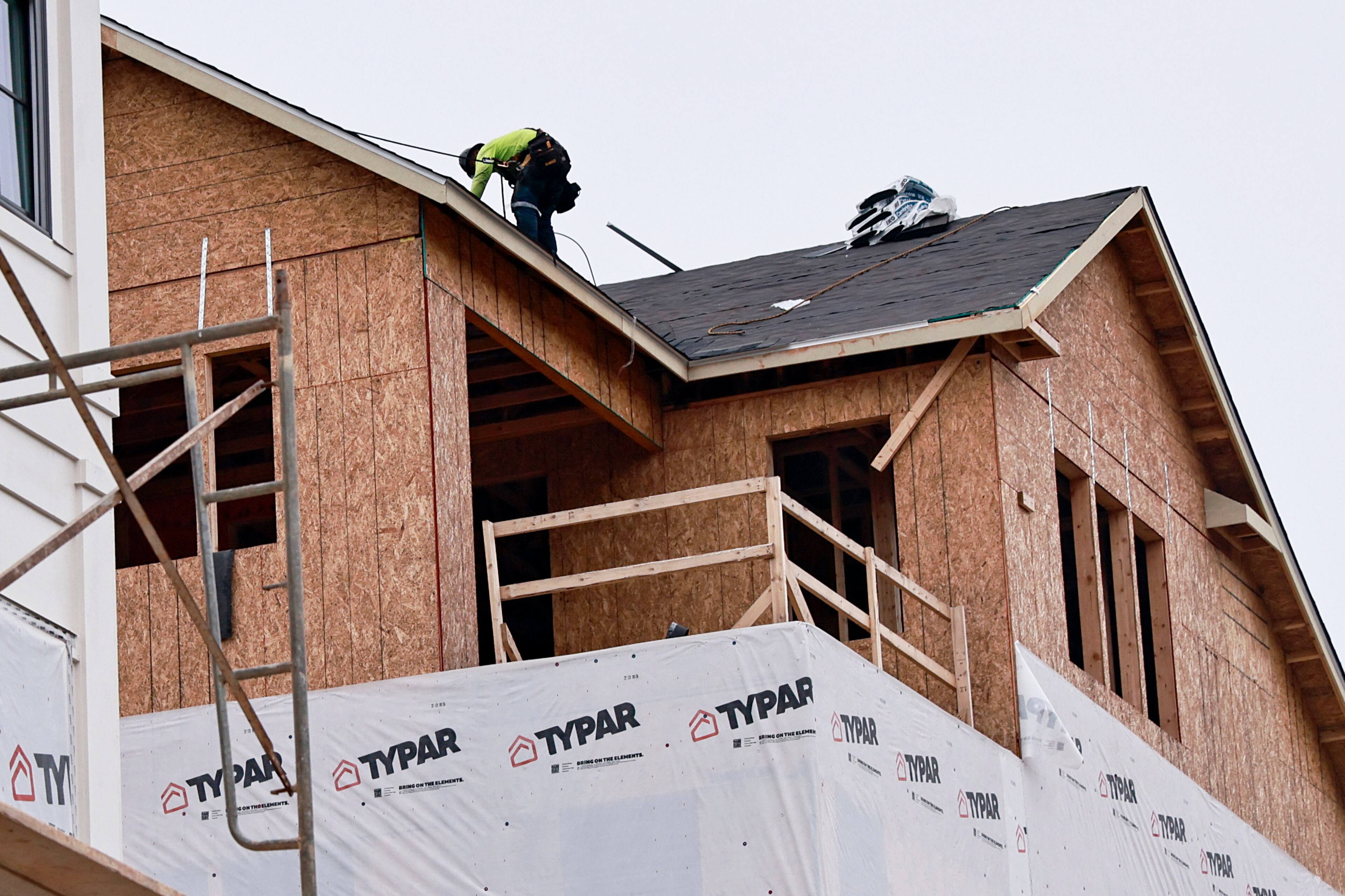 A worker continues construction on a luxury townhouse at Foundry by JW Homes in Alpharetta on Friday, August 19, 2022. (Natrice Miller/AJC)