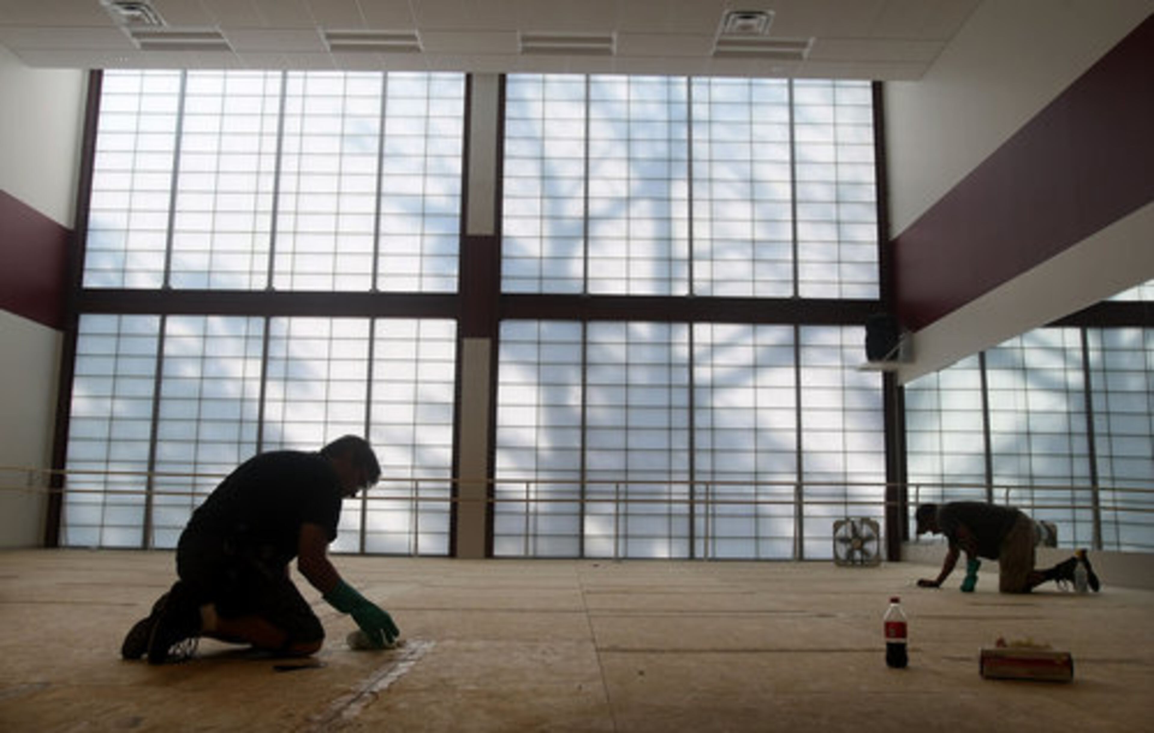 Mike Alphin and Reggie Jefferson lay a "sprung" floor in one of the dance studios.