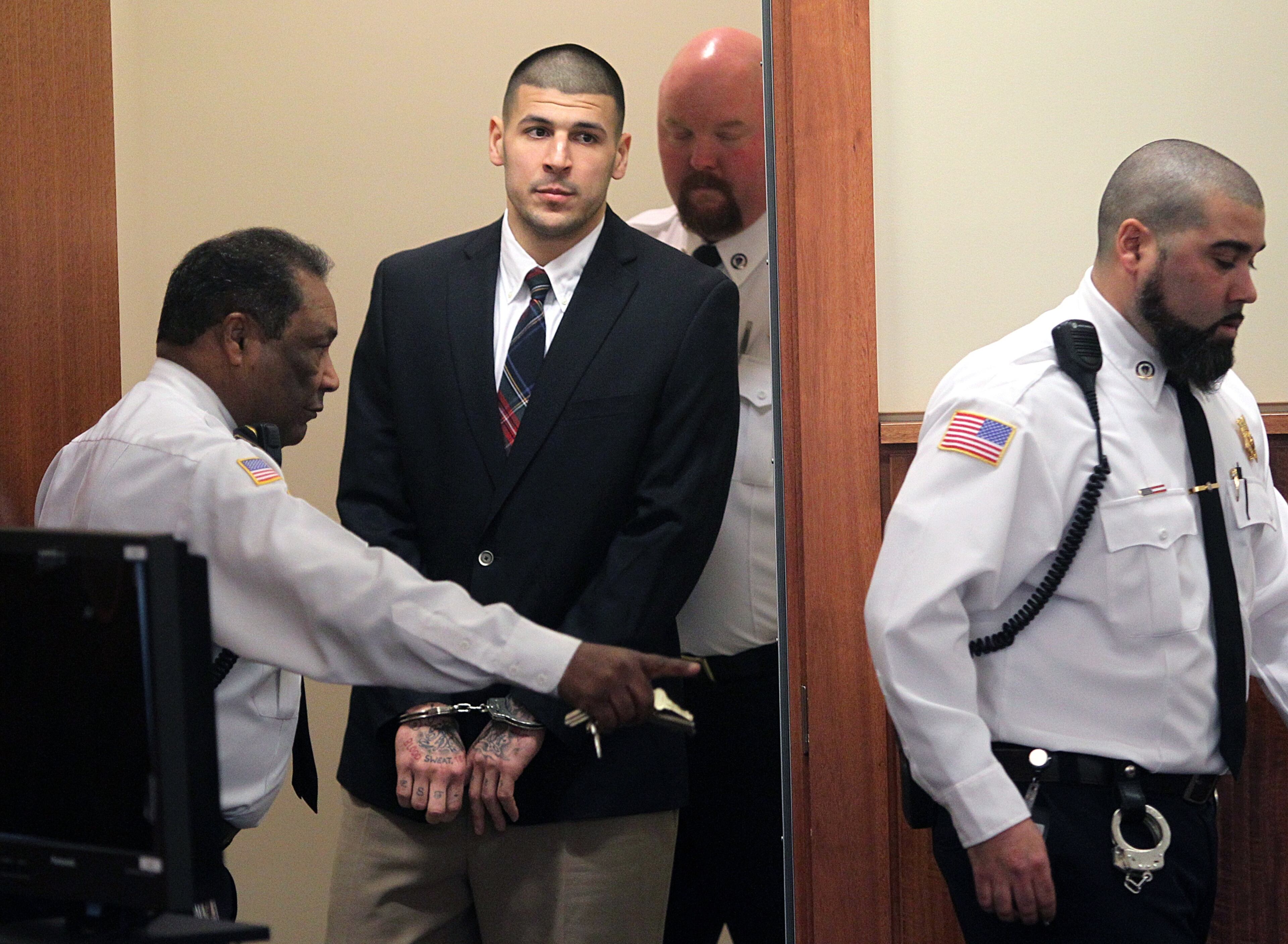 Former New England Patriots NFL football player Aaron Hernandez is led into his court appearance at the Fall River Superior Court in Fall River, Mass., Monday, Dec. 23, 2013.
