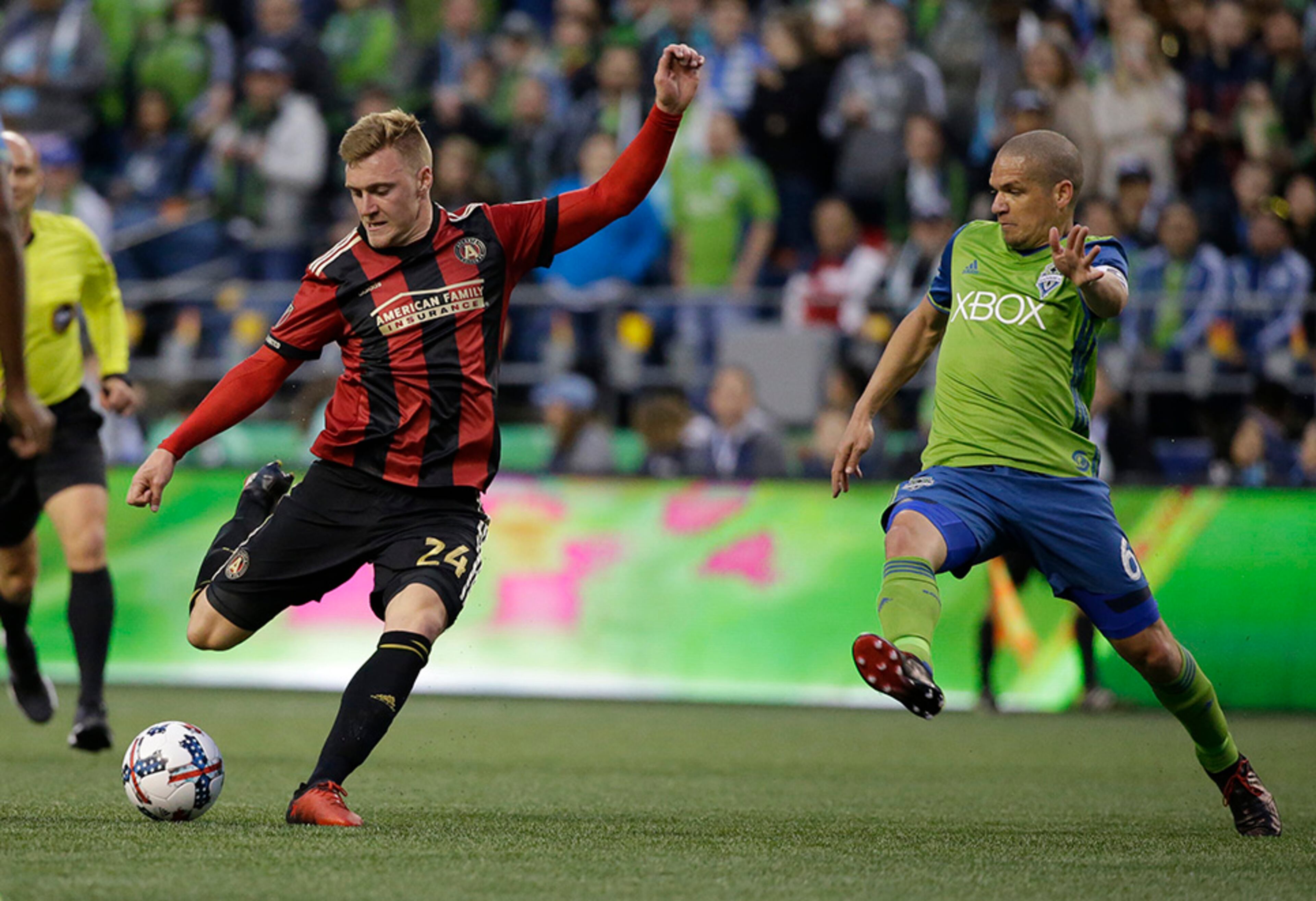 Atlanta United midfielder Julian Gressel, left gets a shot on goal off under pressure from Seattle Sounders midfielder Osvaldo Alonso, right, in the first half of an MLS soccer match, Friday, March 31, 2017, in Seattle. (AP Photo/Ted S. Warren)