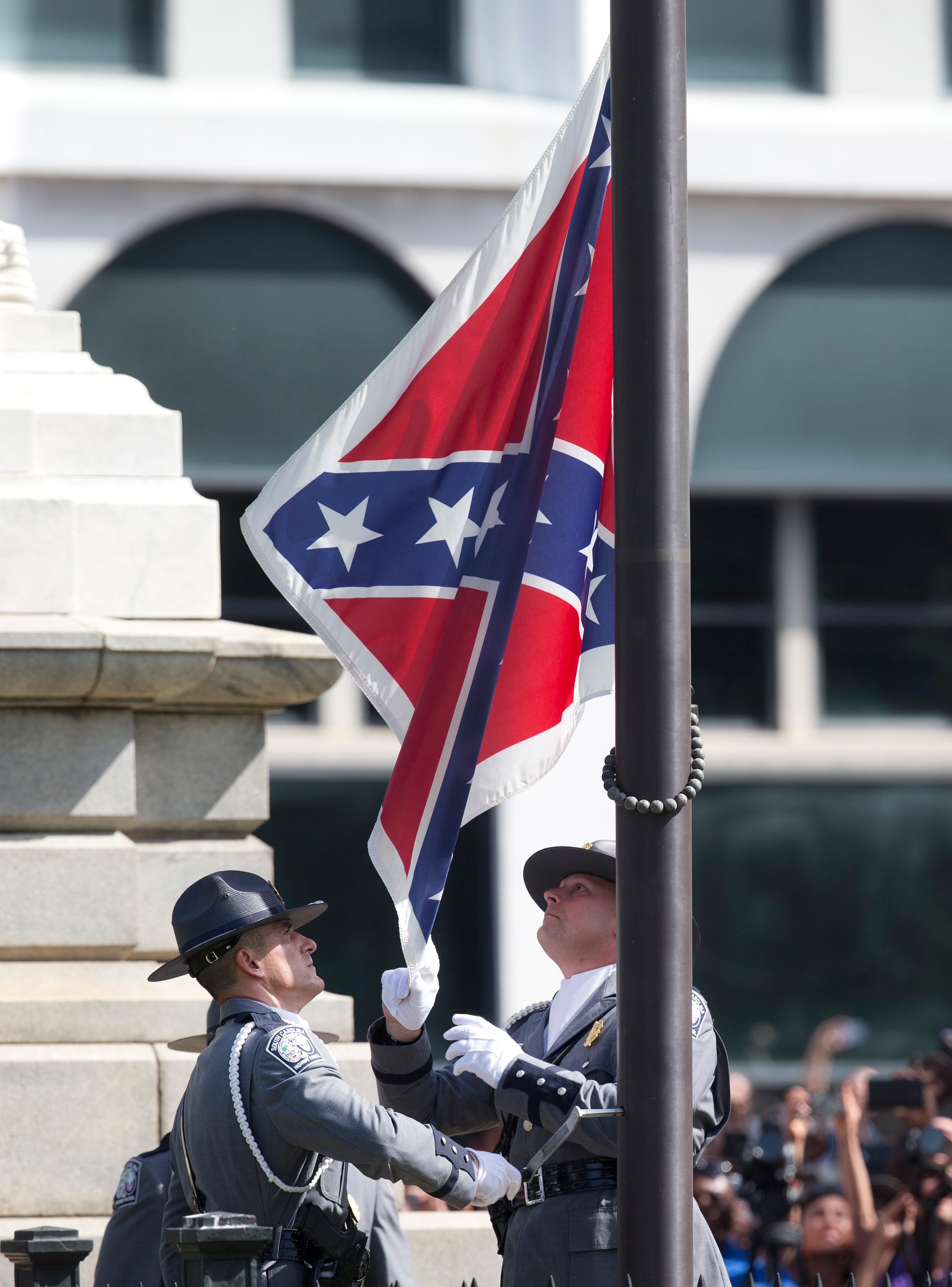 An honor guard from the South Carolina Highway patrol removes the Confederate battle flag from the Capitol grounds in Columbia, S.C., Friday, July 10, 2015, ending its 54-year presence there. (AP Photo/John Bazemore)