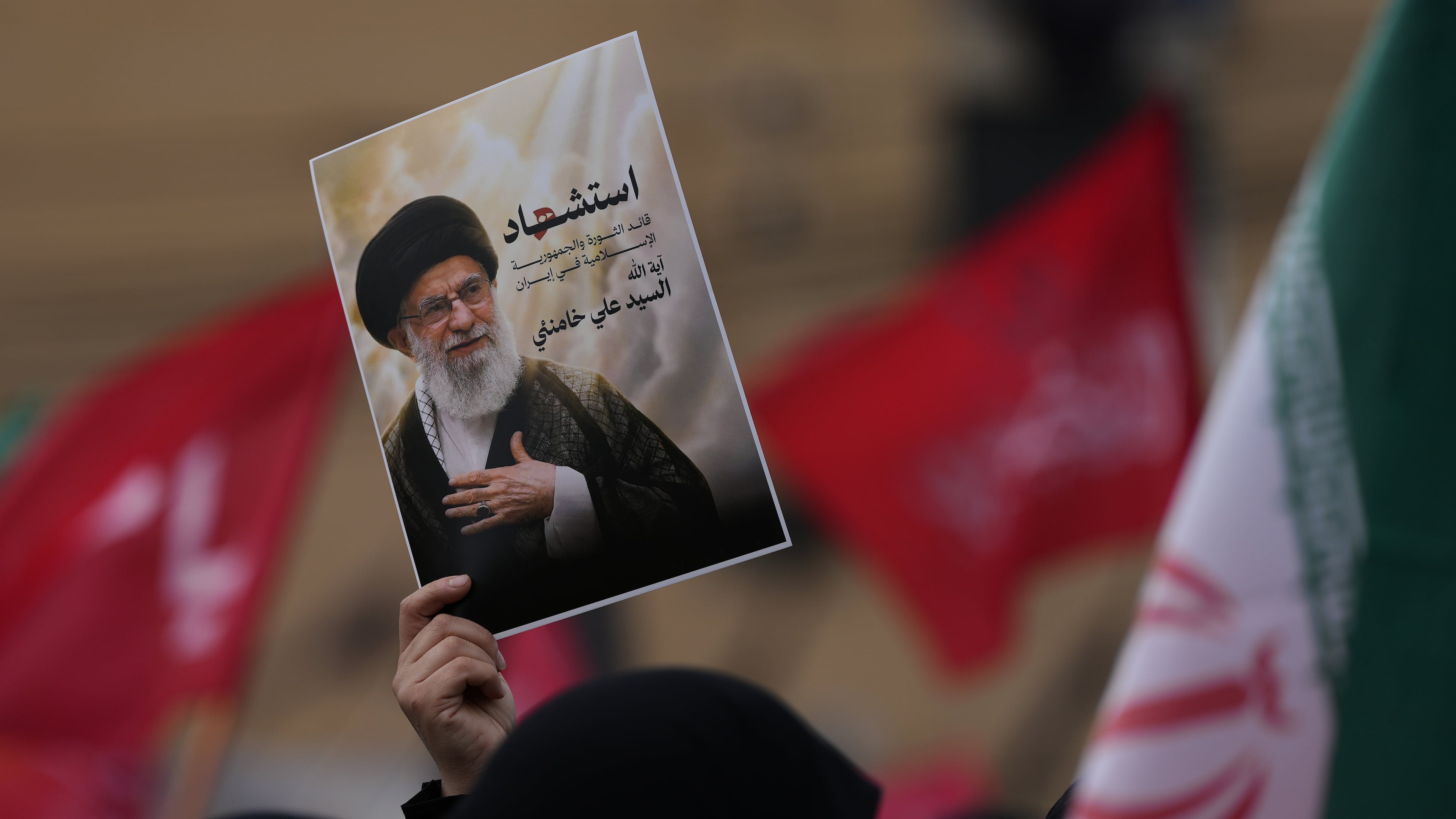 A Hezbollah supporter holds up a portrait of the late Iranian Supreme Leader Ayatollah Ali Khamenei during a gathering in the southern suburbs of Beirut, Lebanon, Sunday, March 1, 2026. The Arabic words on the portrait read:"Martyrdom of the leader of the Islamic revolution in Iran, sayyed Ayatollah Ali Khamenei." (AP Photo/Hassan Ammar)