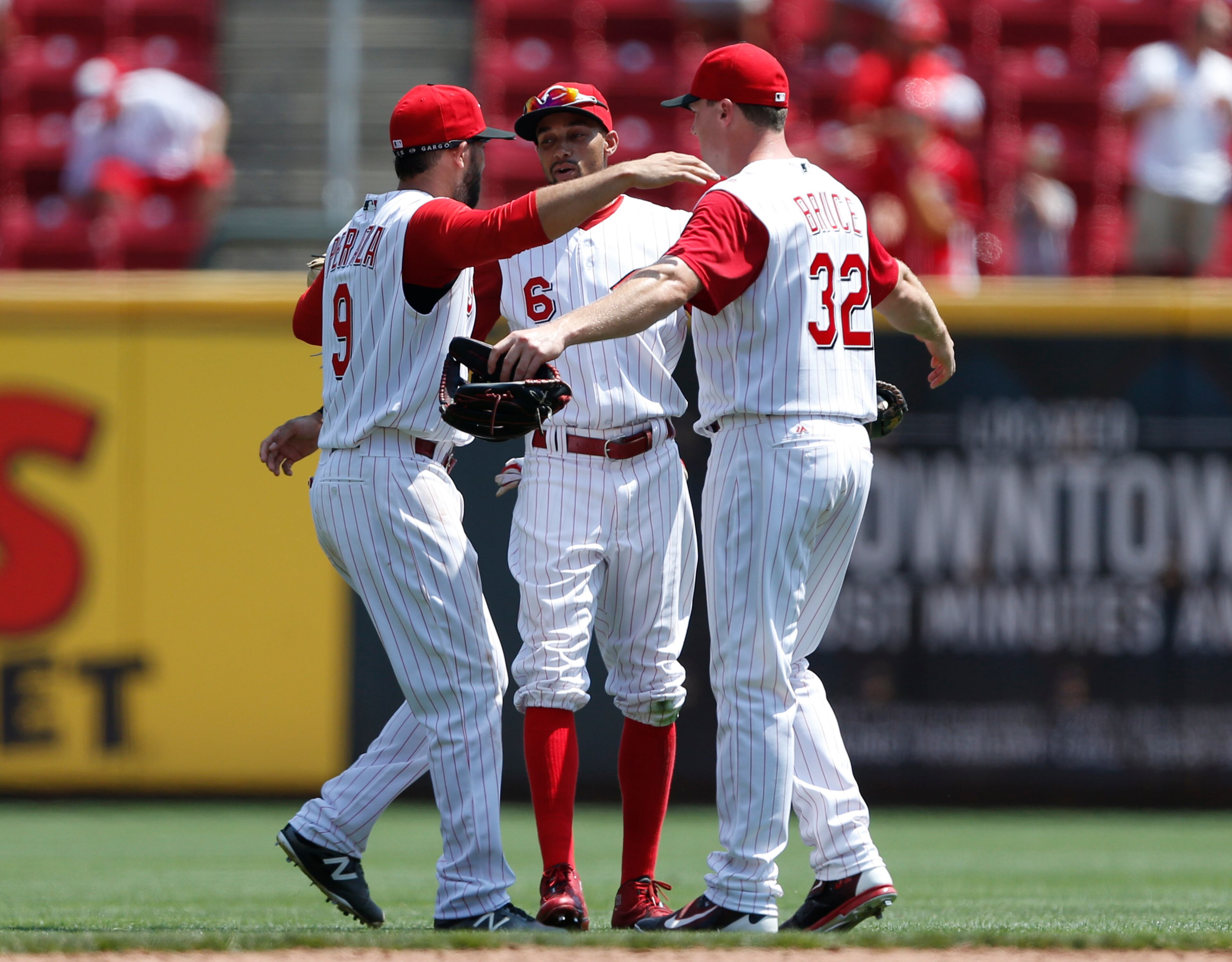 Cincinnati Reds' Jose Peraza, left, Billy Hamilton, center, and Jay Bruce, celebrate their 6-3 win over the Atlanta Braves in a baseball game, Wednesday, July 20, 2016, in Cincinnati. (AP Photo/Gary Landers)