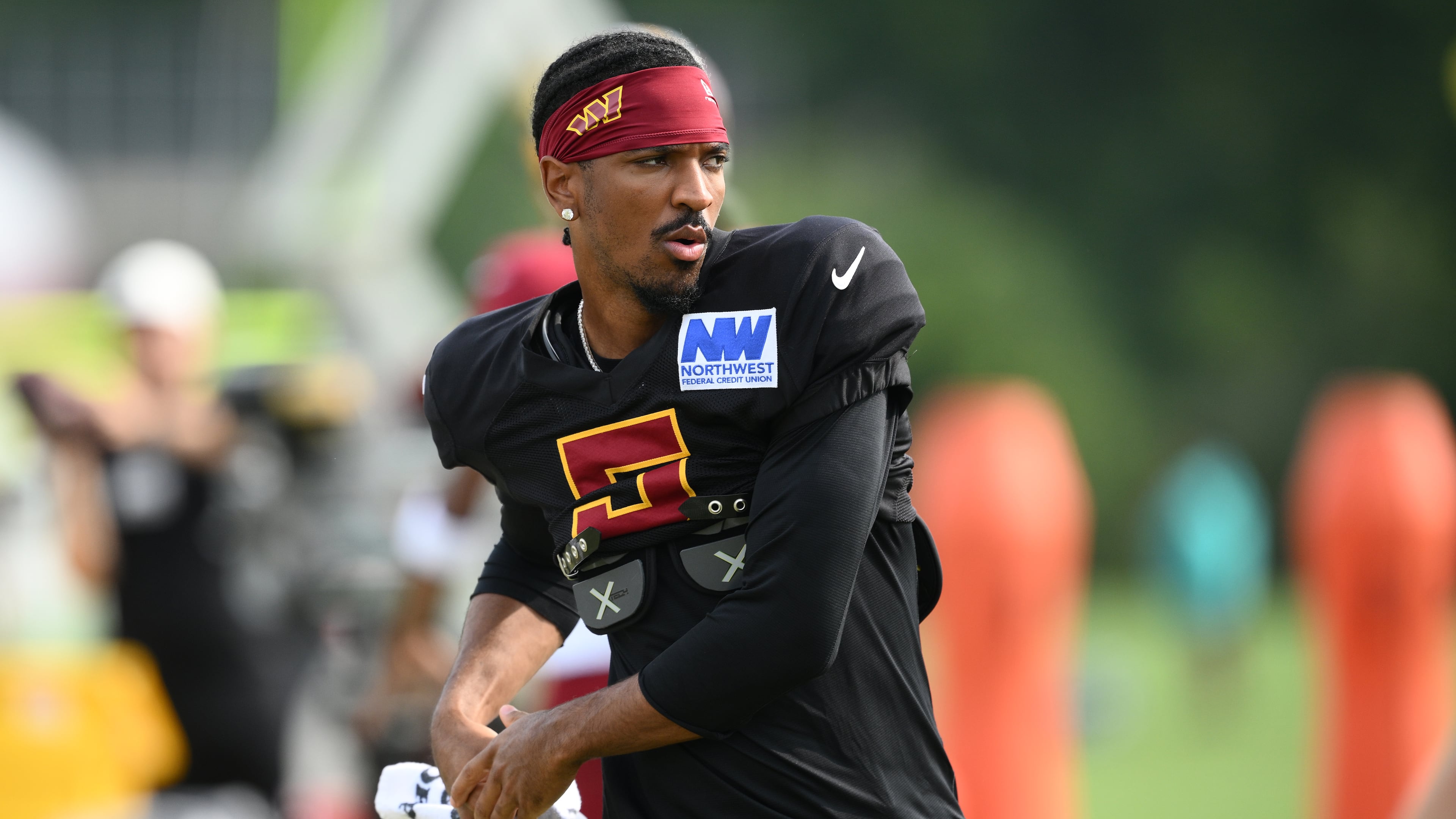 Washington Commanders quarterback Jayden Daniels works out before a joint practice with the Miami Dolphins at NFL football training camp, Wednesday, Aug. 12, 2026 in Ashburn, Va. (AP Photo/Nick Wass)