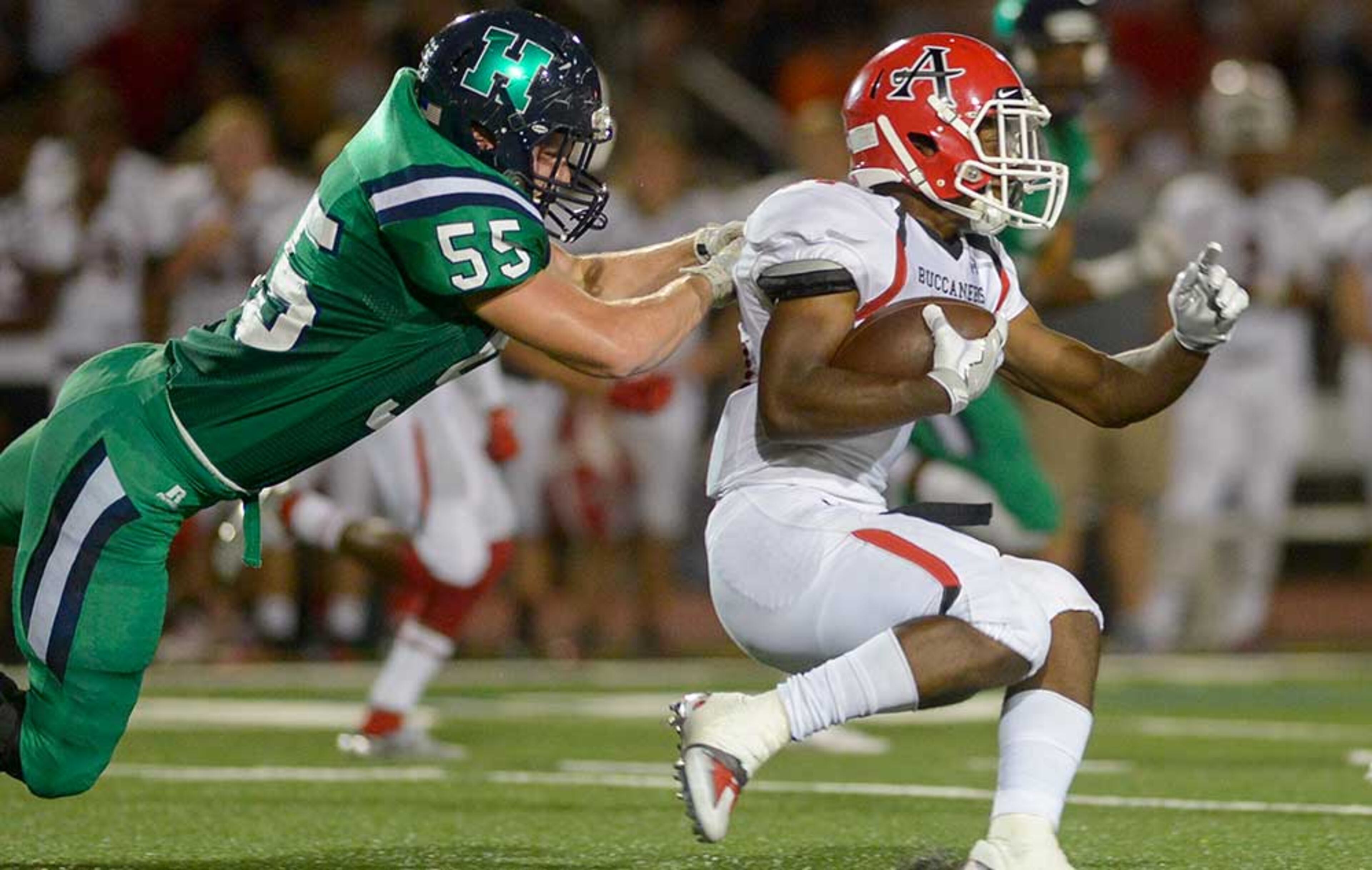 Harrison senior LB Robert Fisher (55) attempts to stop Allatoona senior RB Charles Anderson (14) in the first half of Friday's game.
