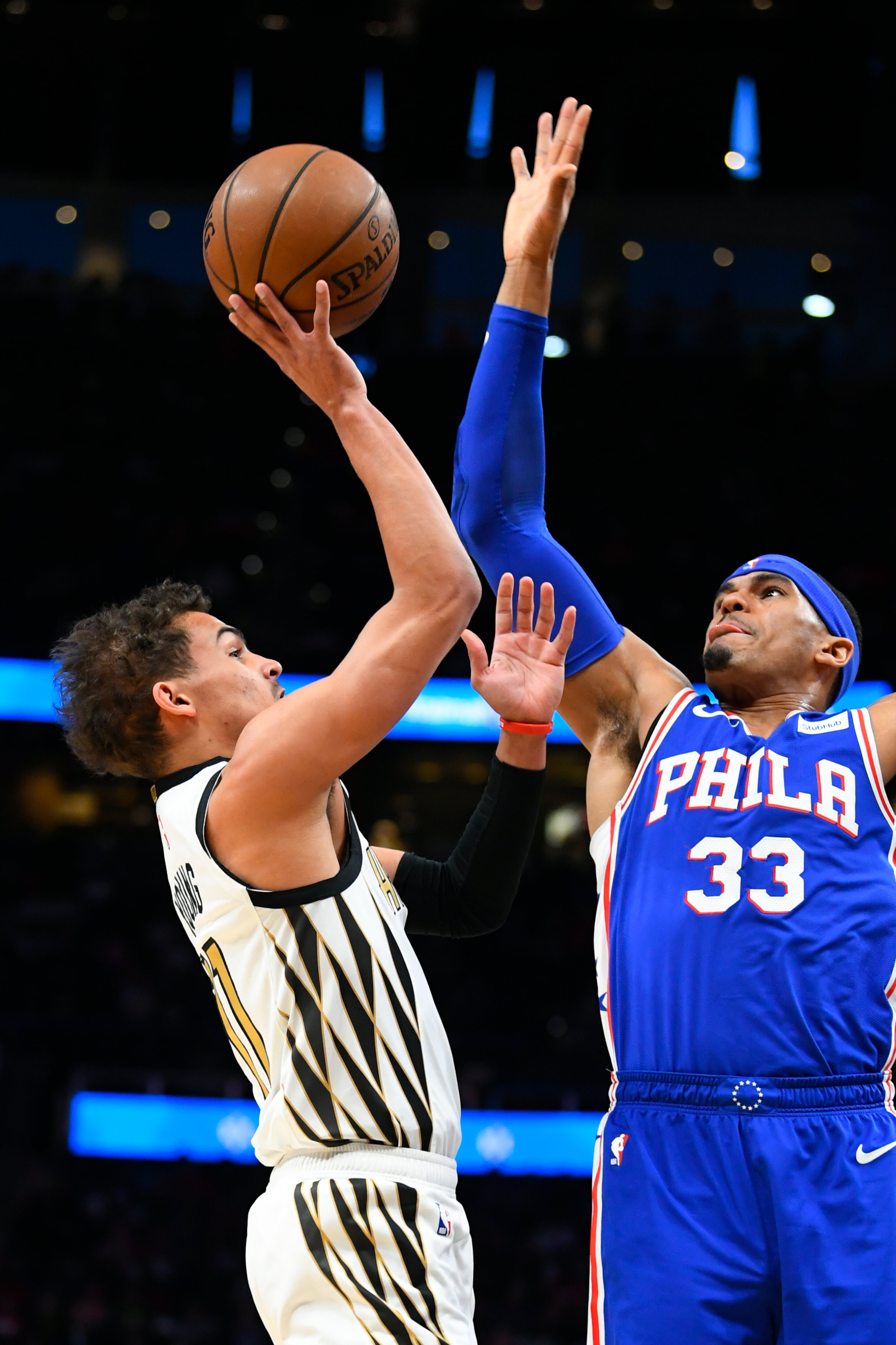 Atlanta Hawks guard Trae Young shoots as Philadelphia 76ers forward Tobias Harris (33) defends during the first half of an NBA basketball game Saturday, March 23, 2019, in Atlanta. (AP Photo/John Amis)