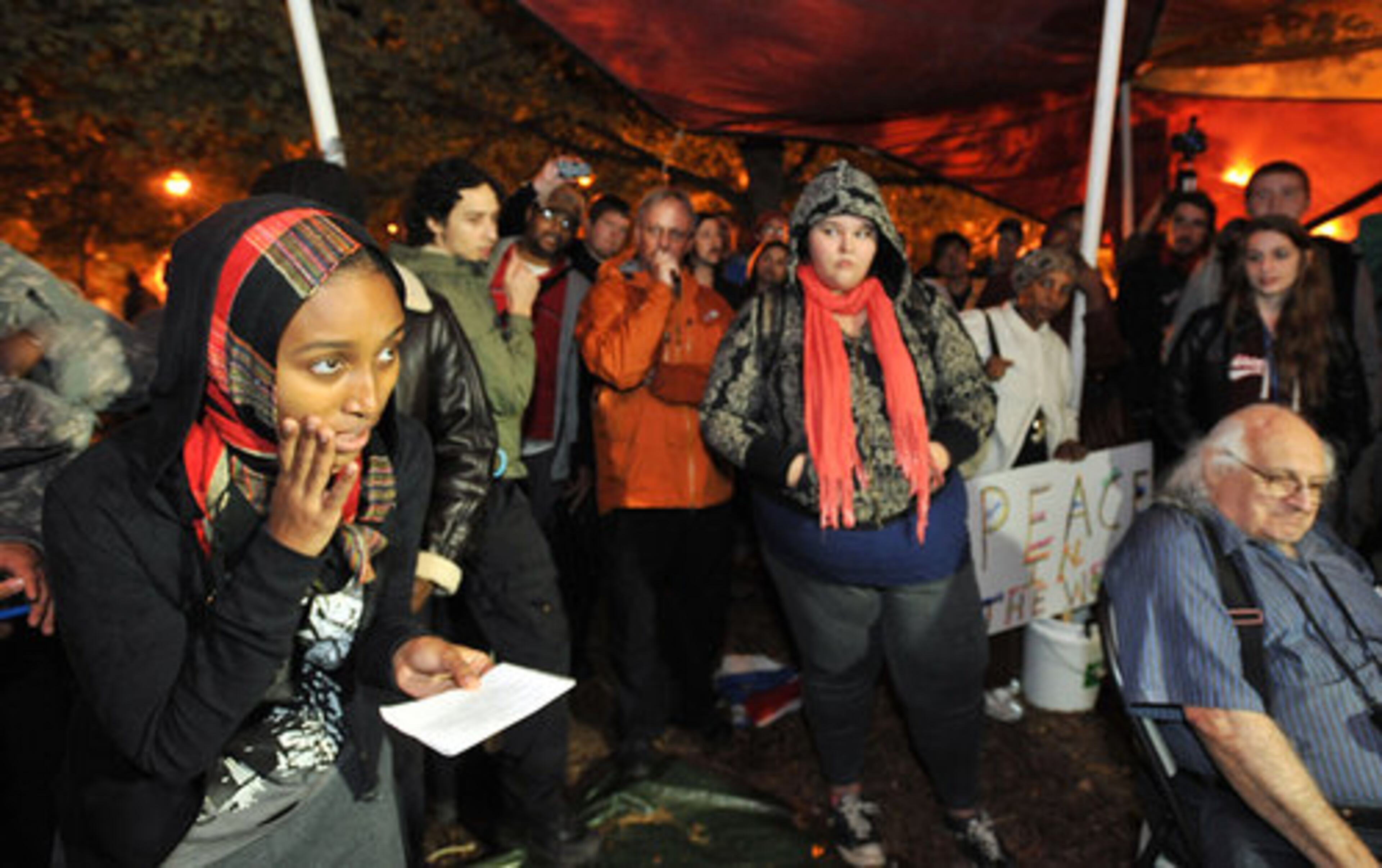 Occupy Atlanta participant Leila Abadir (left) reads a message from Atlanta Mayor's office out loud during an assembly Thursday night, a day after Atlanta Mayor Kasim Reed issued an executive order giving Occupy Atlanta protesters until 5 p.m. Monday to vacate Woodruff Park.