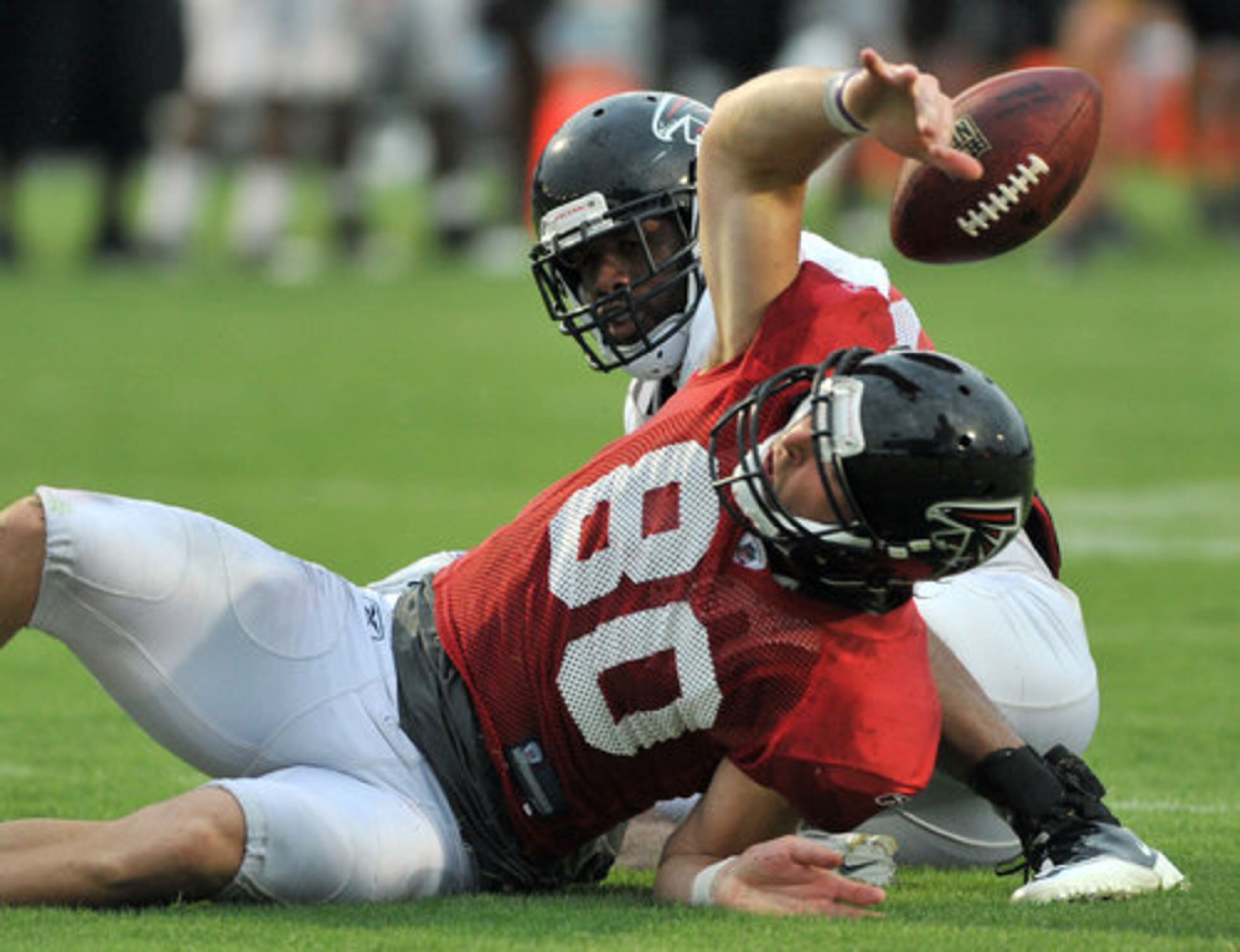 Atlanta Falcons' Kerry Meier (80) looses a ball as Dominique Franks (24) tackles during the Friday Night Lights at North Gwinnett High School in Suwanee.