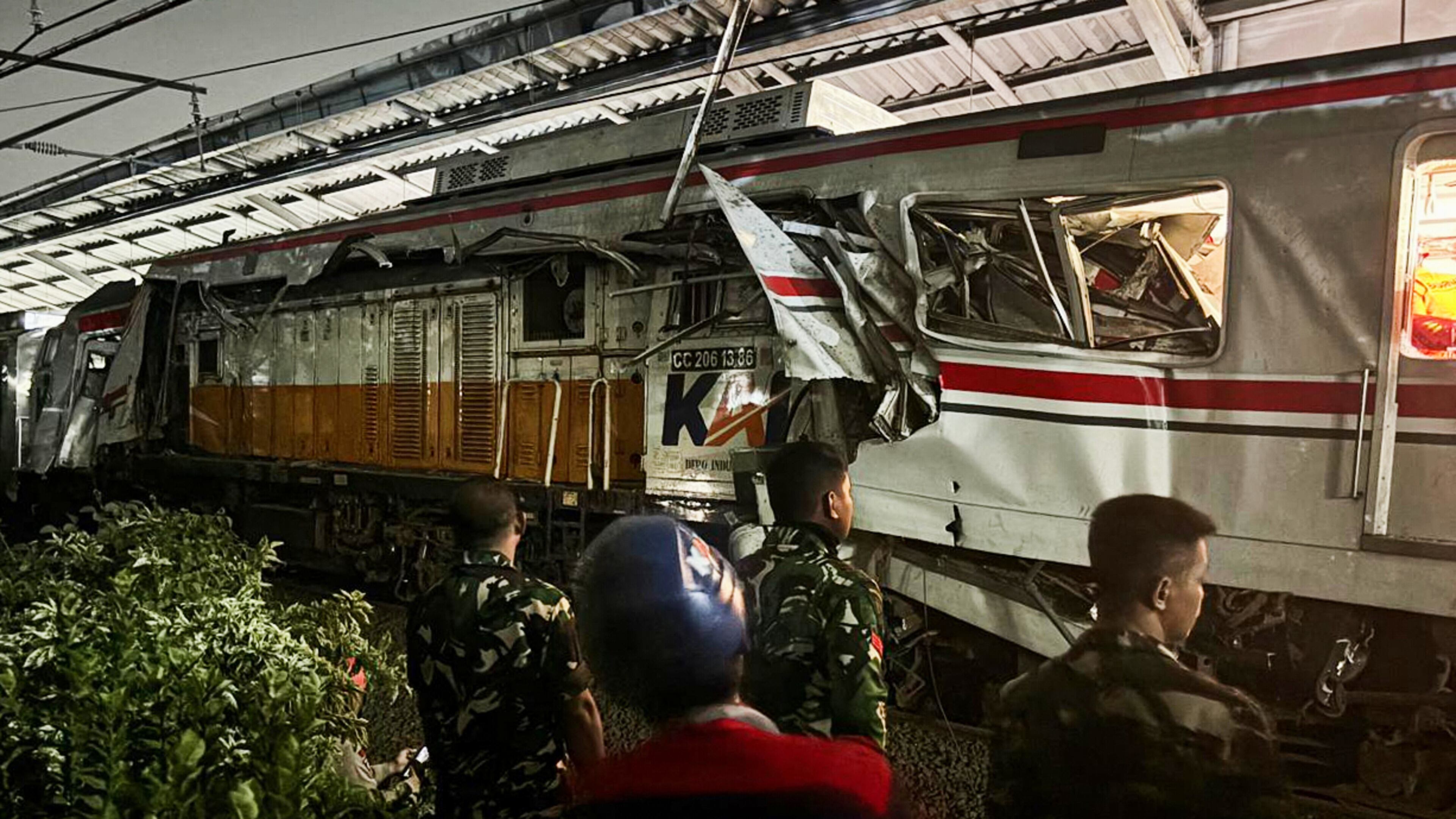 Indonesian soldiers examine the damage after a train crash at a station, in Bekasi, Indonesia, Tuesday, April 28, 2026. (AP Photo/Fadlan Syam)