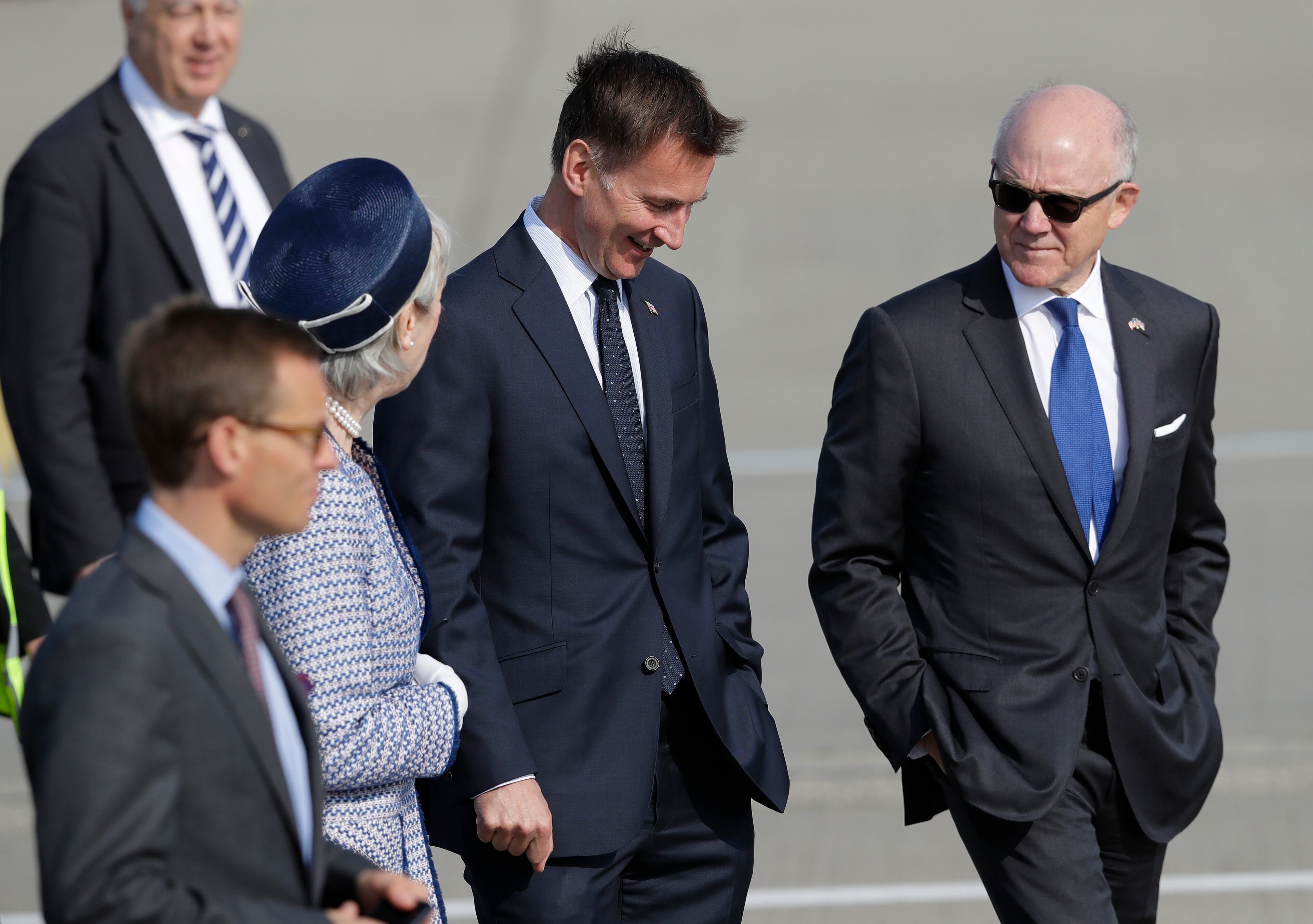 U.S. Ambassador to Britain Woody Johnson, right, and Britain's Foreign Secretary Jeremy Hunt, center, chat as they wait for President Donald Trump and first lady Melania Trump to arrive at Stansted Airport in England, Monday, June 3, 2019 at the start of a three day state visit to Britain. (AP Photo/Kirsty Wigglesworth)