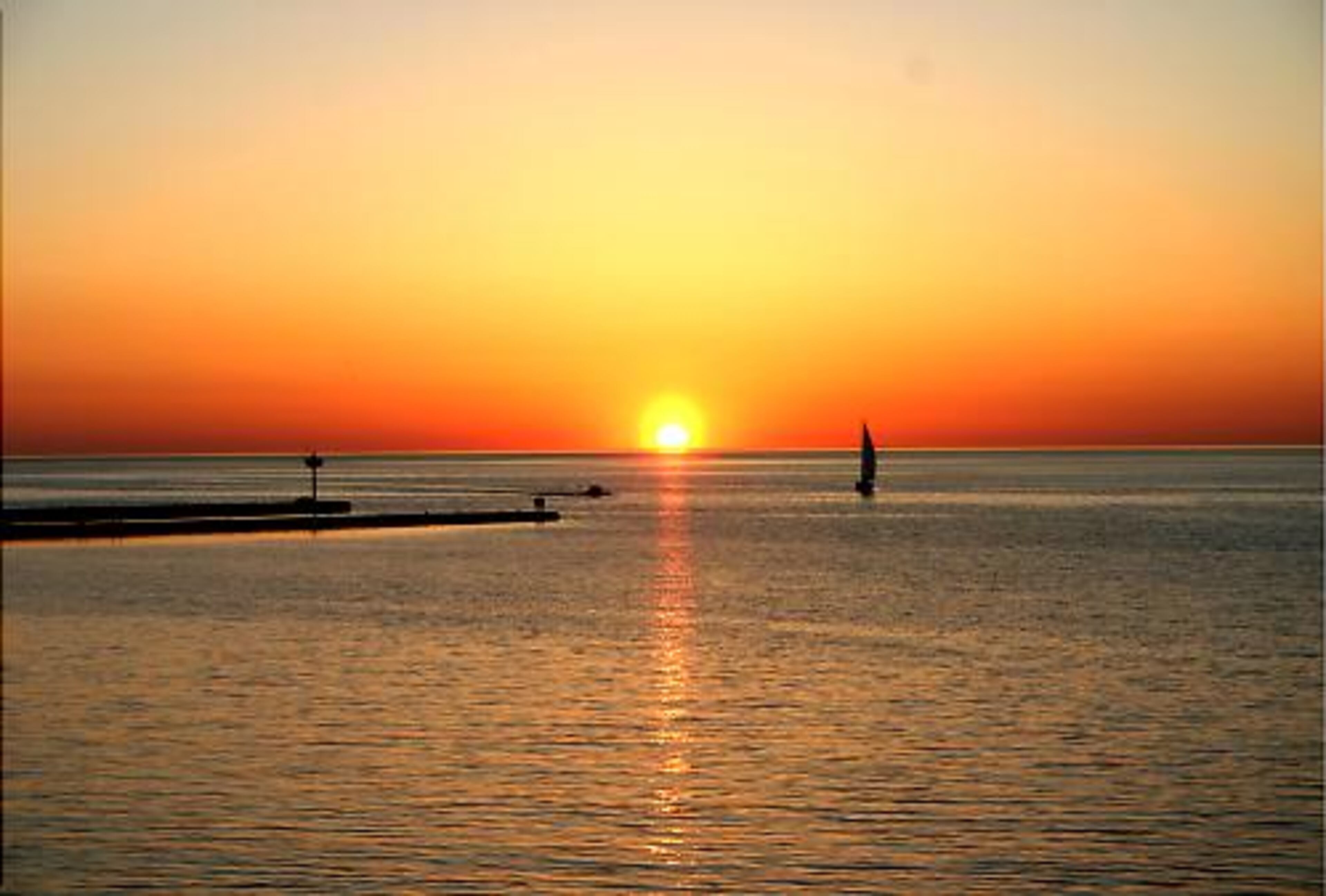 A sunset is shown on Lake Ontario in Niagara County, where the warming effect of the lake extends the growing season of the Niagara Wine Trail, southward to the Niagara Escarpment.