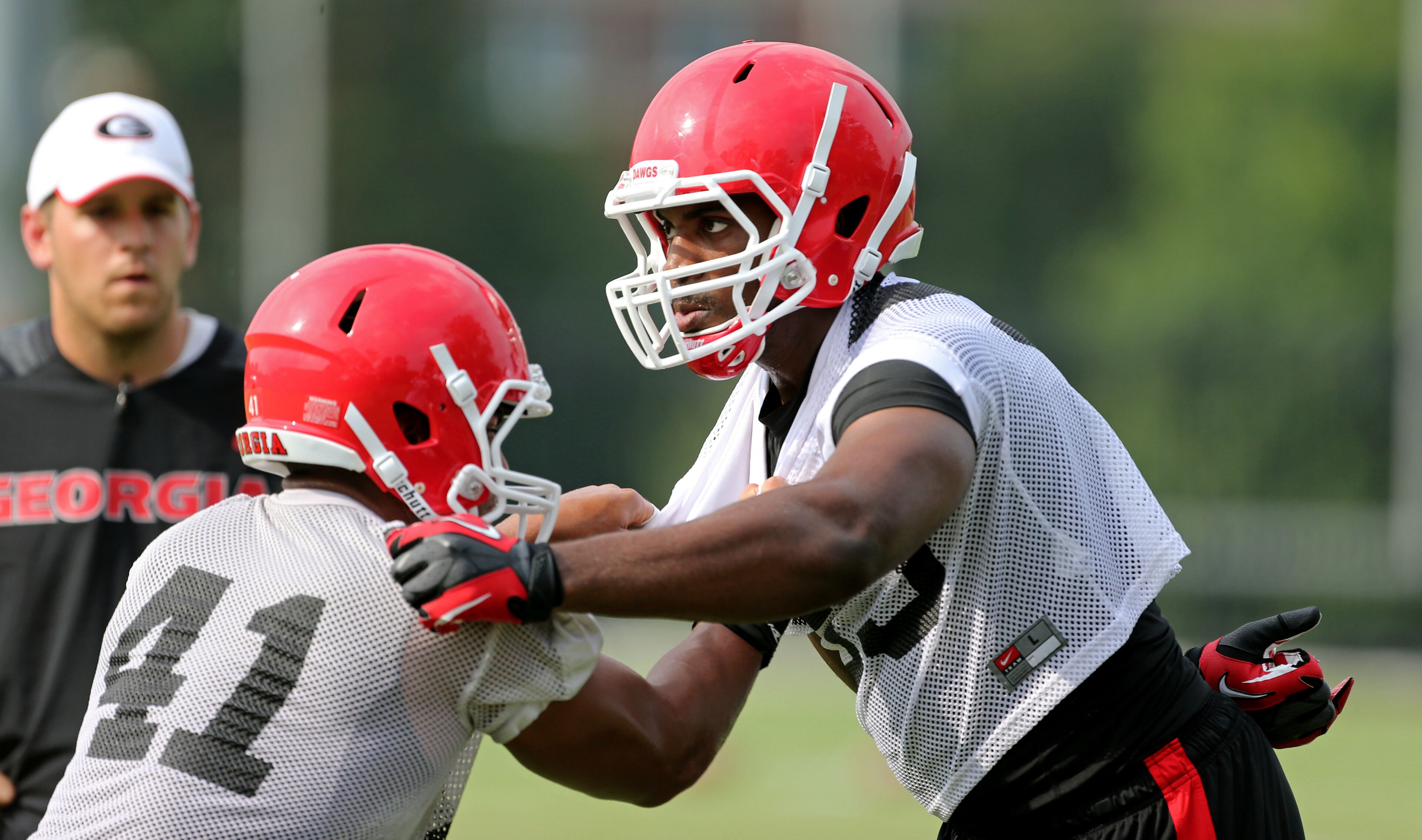 University of Georgia outside linebacker Jordan Jenkins (59, right) participates in a drill with fellow outside linebacker Brandon Burrows (41) during preseason practice at the University of Georgia Tuesday afternoon in Athens, Ga., August 6, 2013. Jenkins, a sophomore from Harris County High School, is replacing All-American outside linebacker Jarvis Jones who left for the 2013 NFL draft. JASON GETZ / JGETZ@AJC.COM