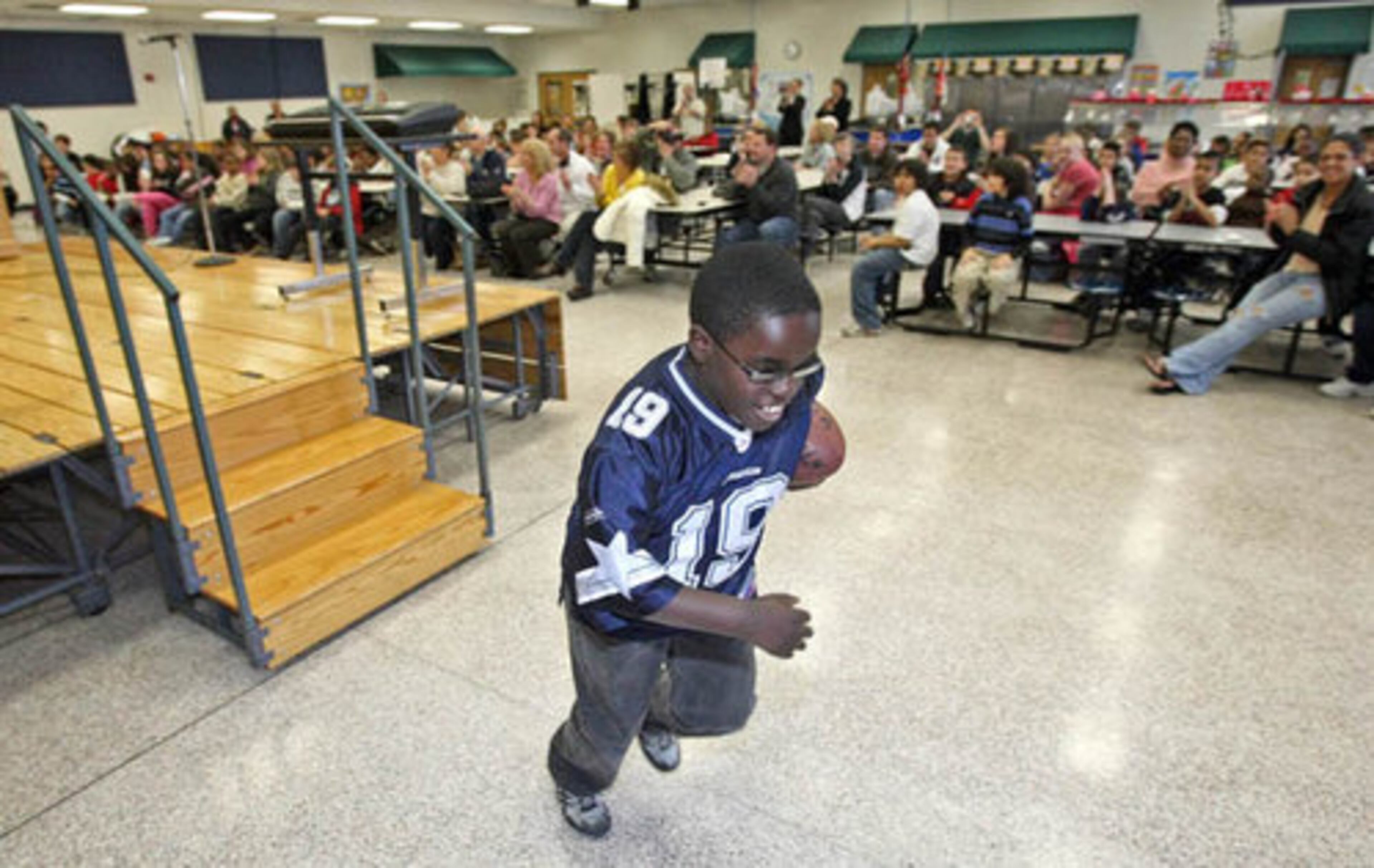 Christian Ellis, 10, runs off of the stage after portraying Dallas Cowboy running back Emmitt Smith.