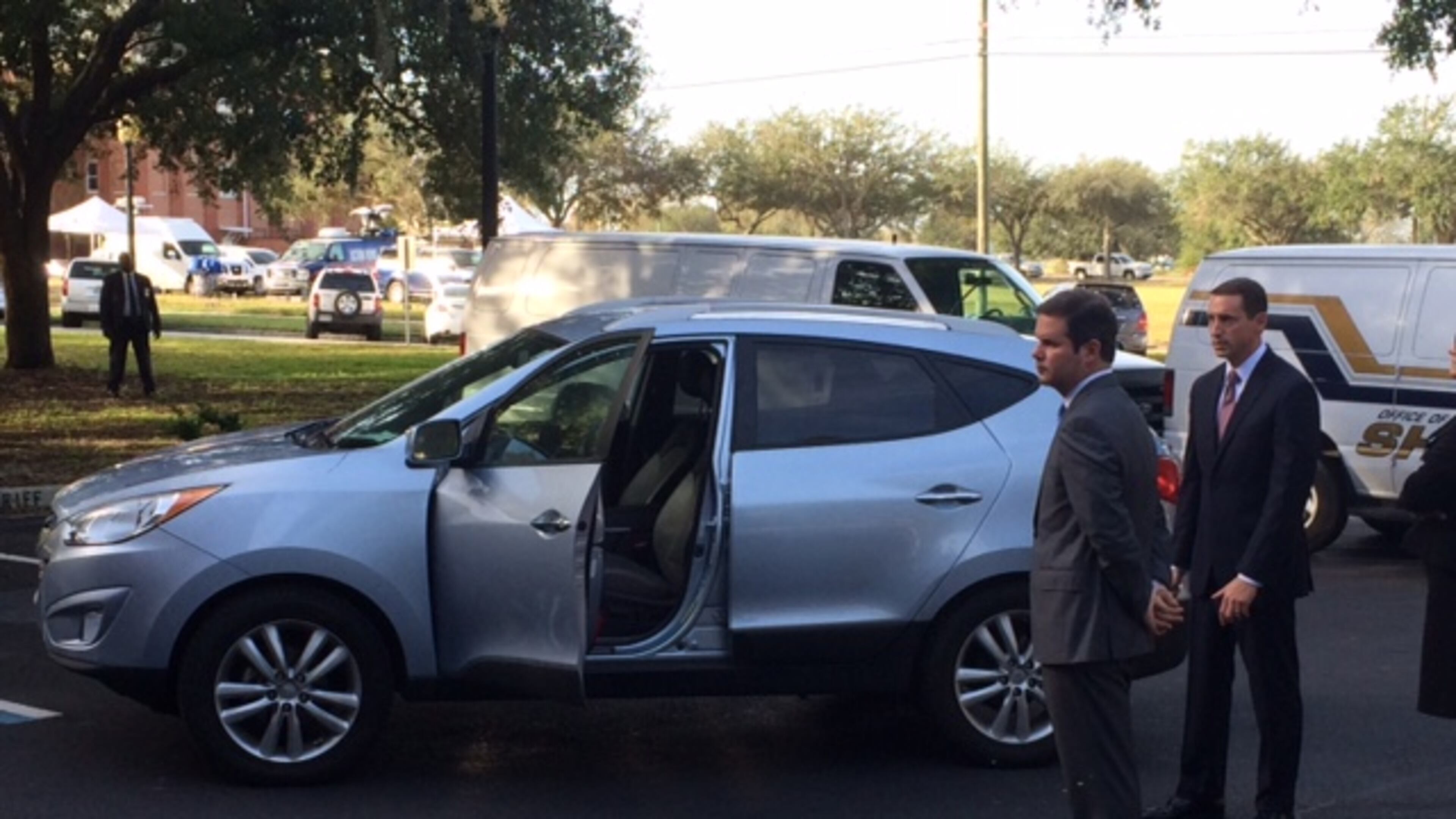 Prosecutors Chuck Boring (left) and Jesse Evans stand outside the 2011 Hyundai Tucson where 22-month-old Cooper Harris died in June 2014. Jurors were allowed to examine the vehicle Thursday morning. (Christian Boone/cboone@ajc.com)
