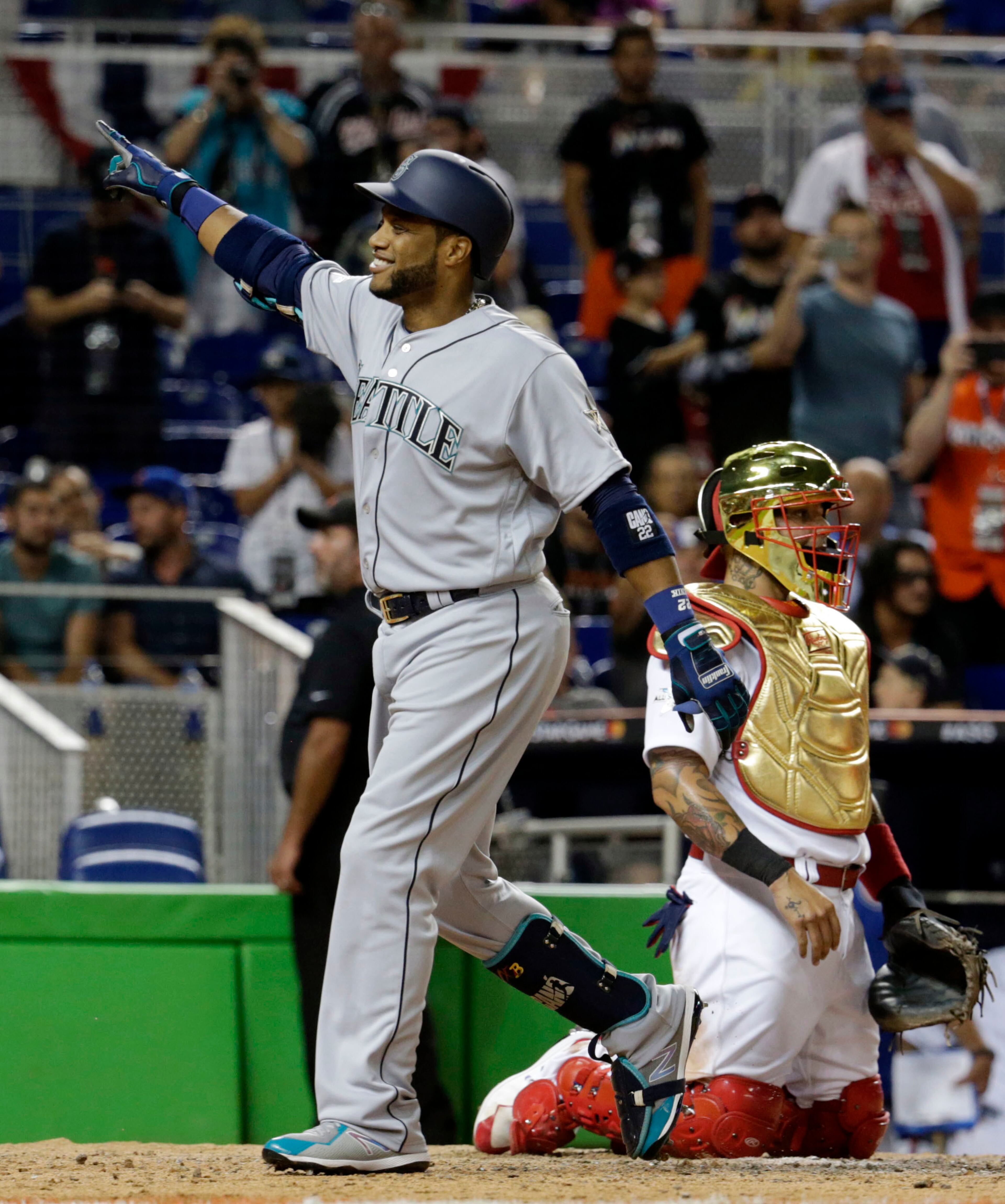 American League's Seattle Mariners Robinson Cano (22), gestures to his team after hitting a home run in the tenth inning, during the MLB baseball All-Star Game, Tuesday, July 11, 2017, in Miami. The American League defeated the National League 2-1. (AP Photo/Lynne Sladky)