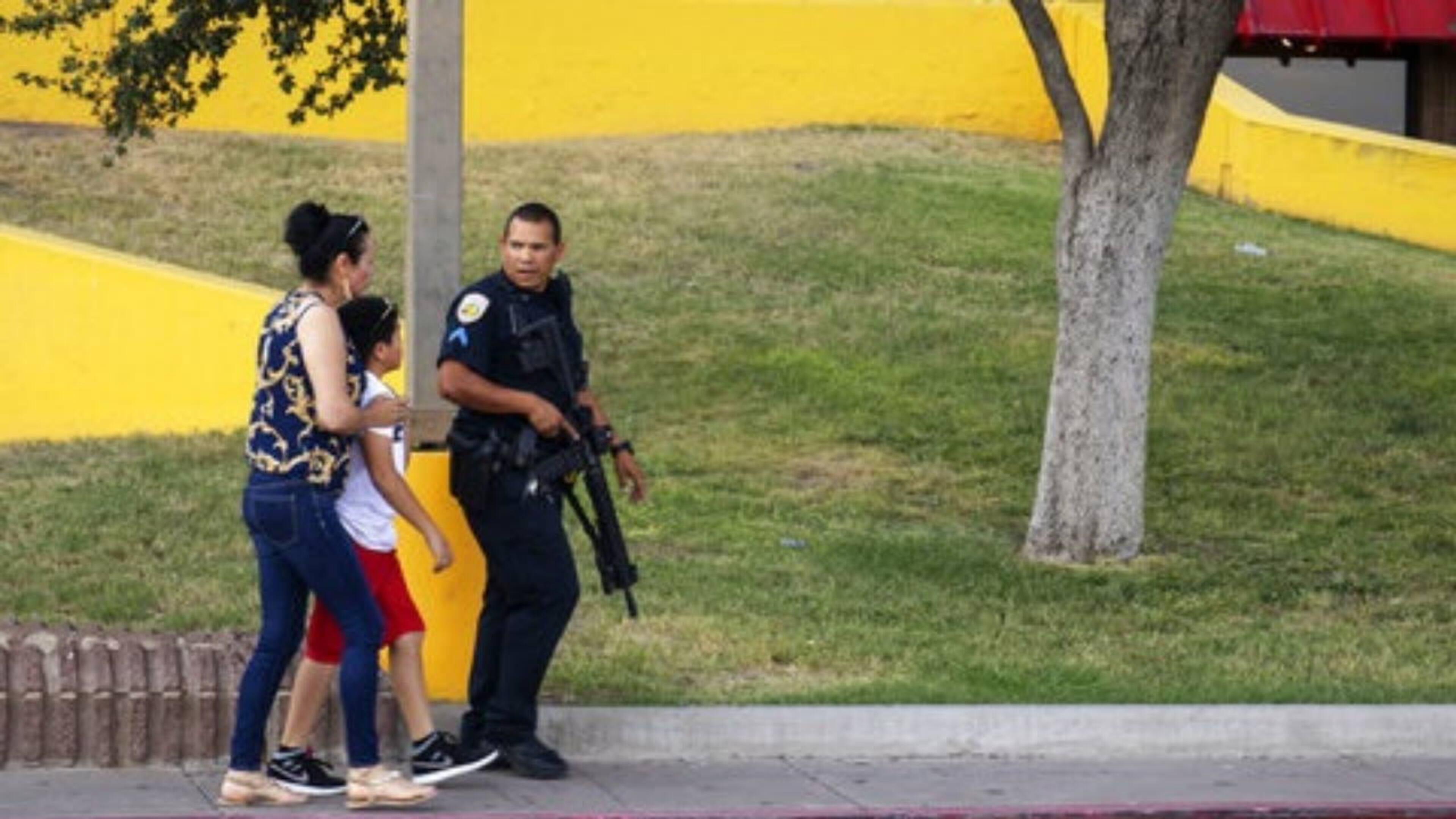 An Odessa police officer escorts bystanders away from an area where a shooting took place in the Texas city Saturday afternoon.