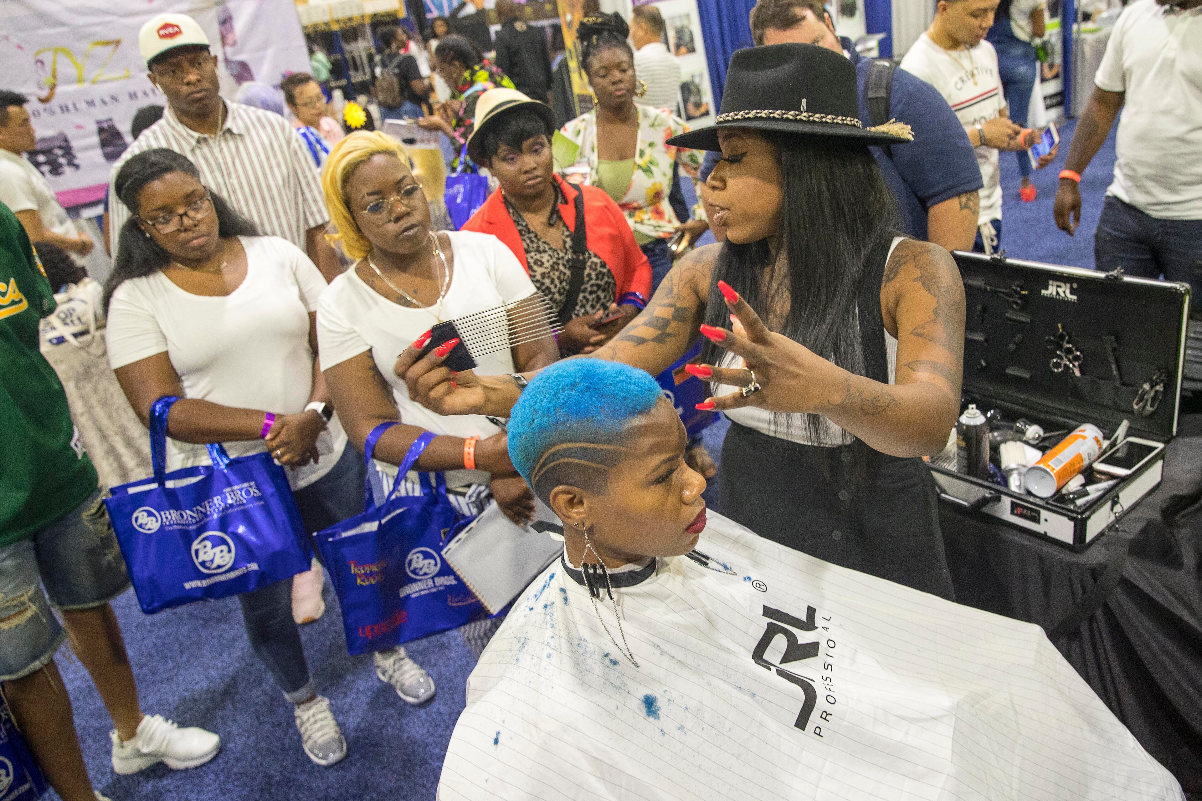 Brandi LaShay explains a technique while styling a model's hair during the Bronner Bros. International Beauty Show at the Georgia World Congress Center in Atlanta, Sunday, August 5, 2018. (Photo: ALYSSA POINTER/ALYSSA.POINTER@AJC.COM)