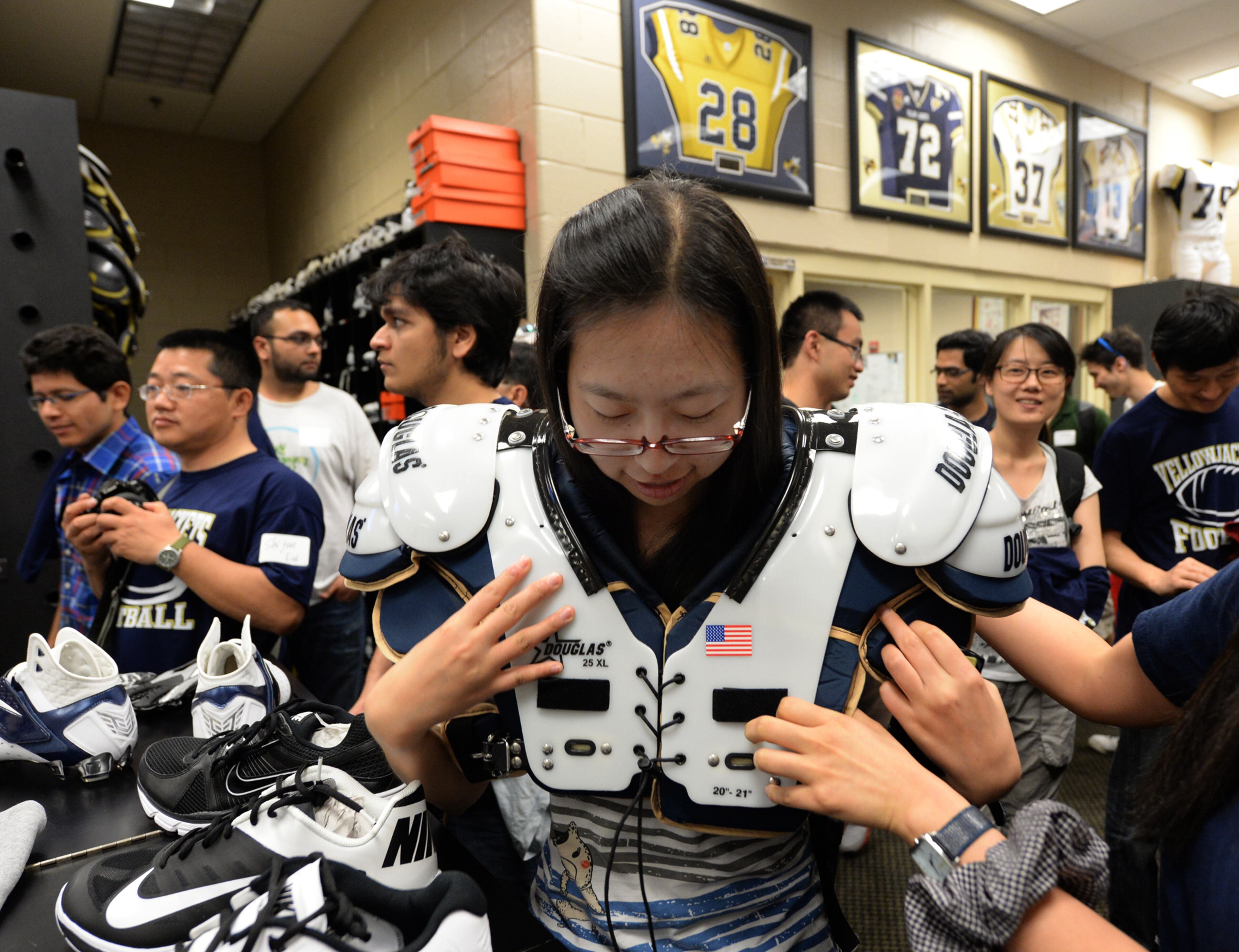 Georgia Tech student Xing Zhang of China puts on shoulder pads.