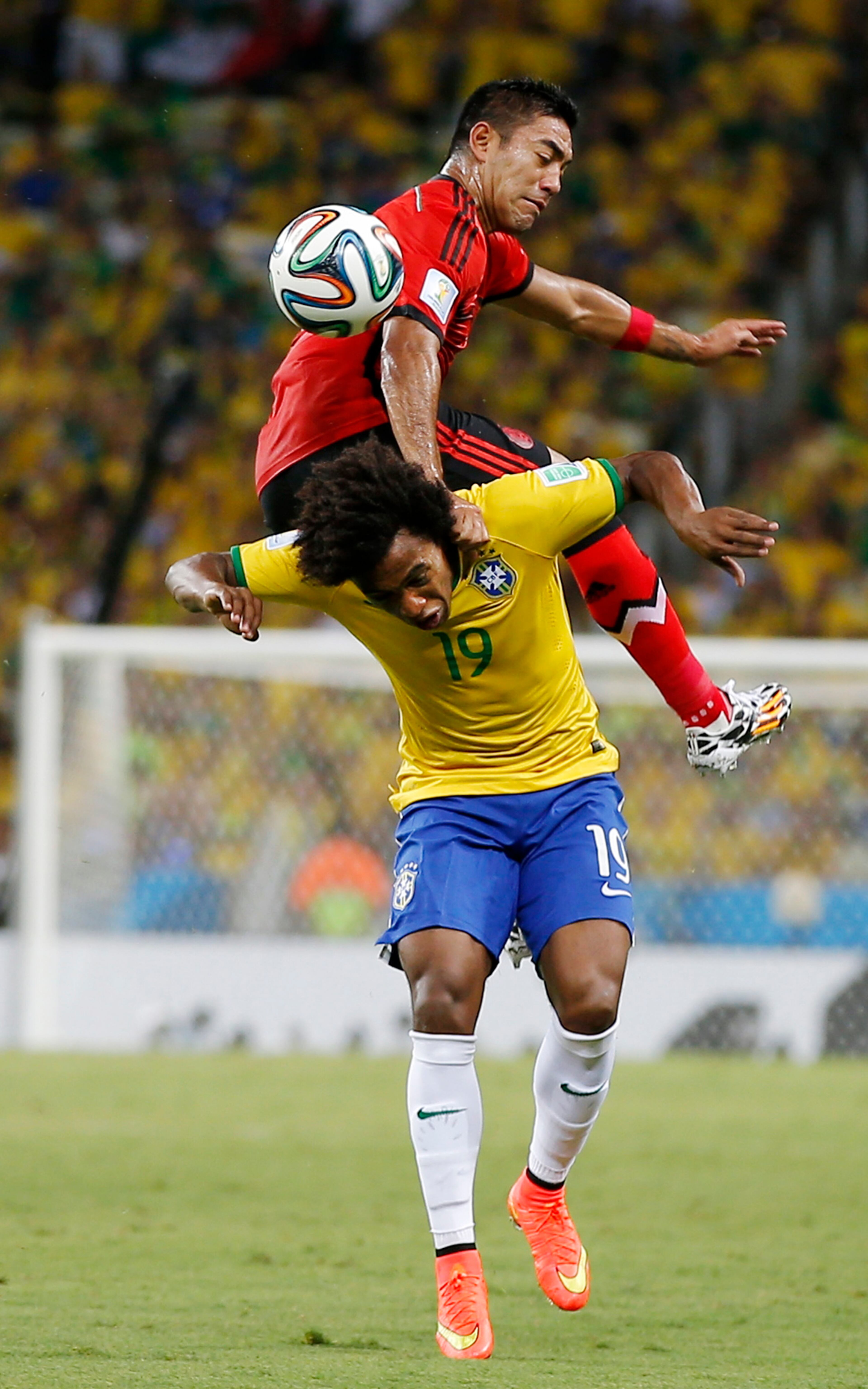 Mexico's Marco Fabian flips over Brazil's Willian while trying to head the ball during the group A World Cup soccer match between Brazil and Mexico at the Arena Castelao in Fortaleza, Brazil, Tuesday, June 17, 2014. (AP Photo/Eduardo Verdugo)