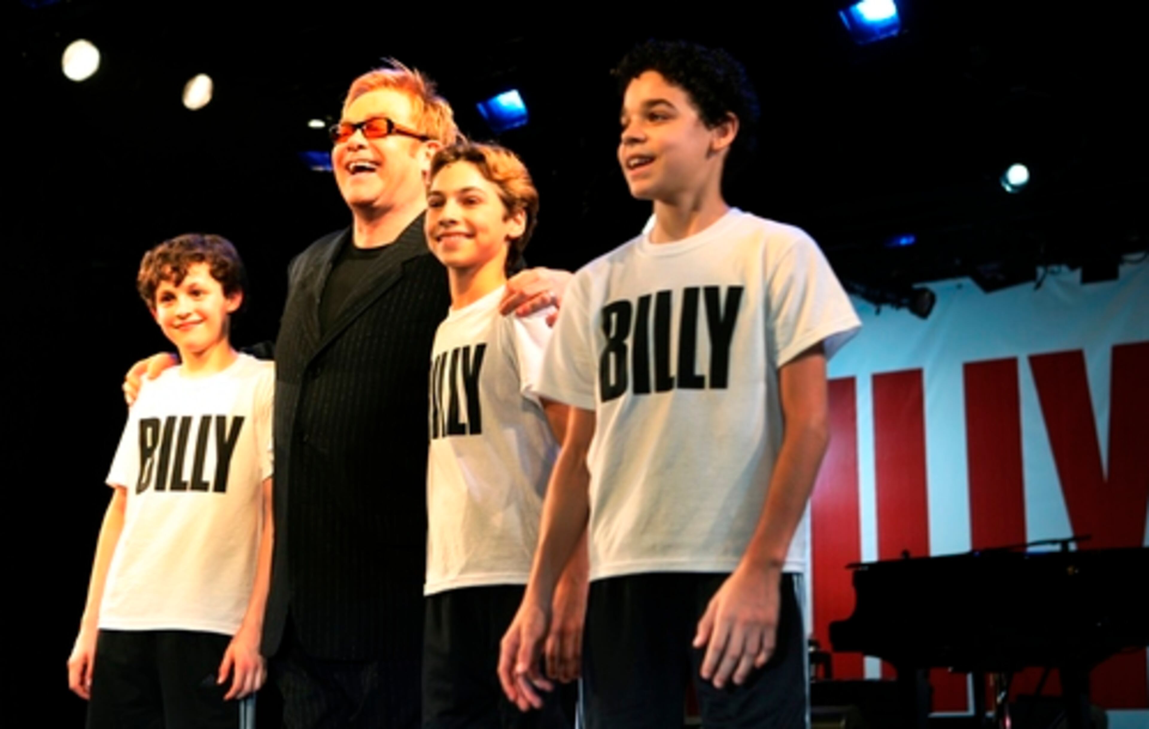 ELTON JOHN (the tall one) poses with the three twinkletoes moppets who will play "Billy Elliot" in the musical of the same name: Trent Kowalik, Kiril Kulish, and David Alvarez. The musical opens on Broadway in October.