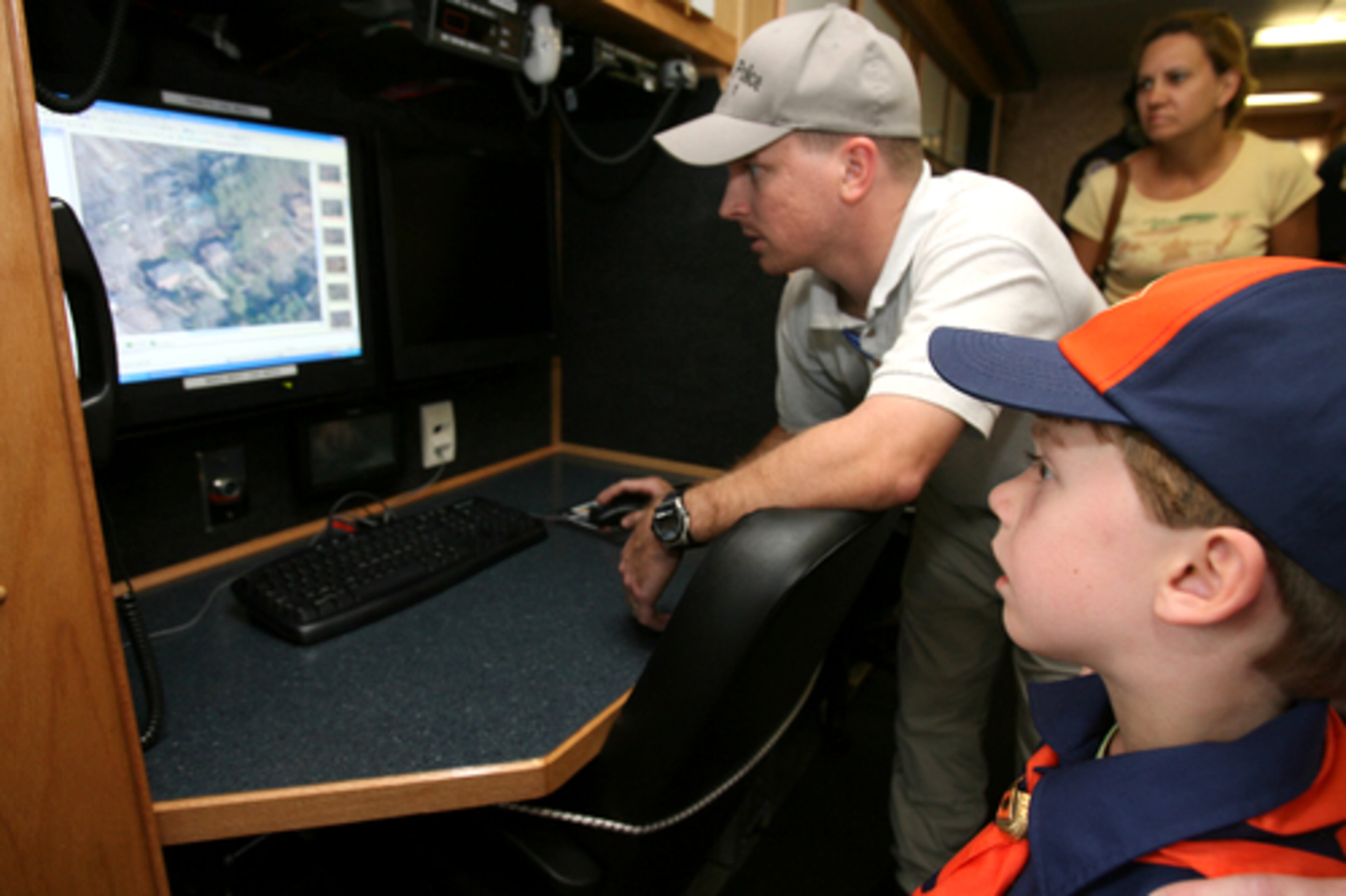 Chris Reagin (left), coordinator of the Gwinnett County Police Mobile Operations Center, shows Sean Comerford (right), of Norcross, an aerial view of his home. The mobile operations center computer program can show officers aerial views of "every square inch of Gwinnett County," Reagin said.