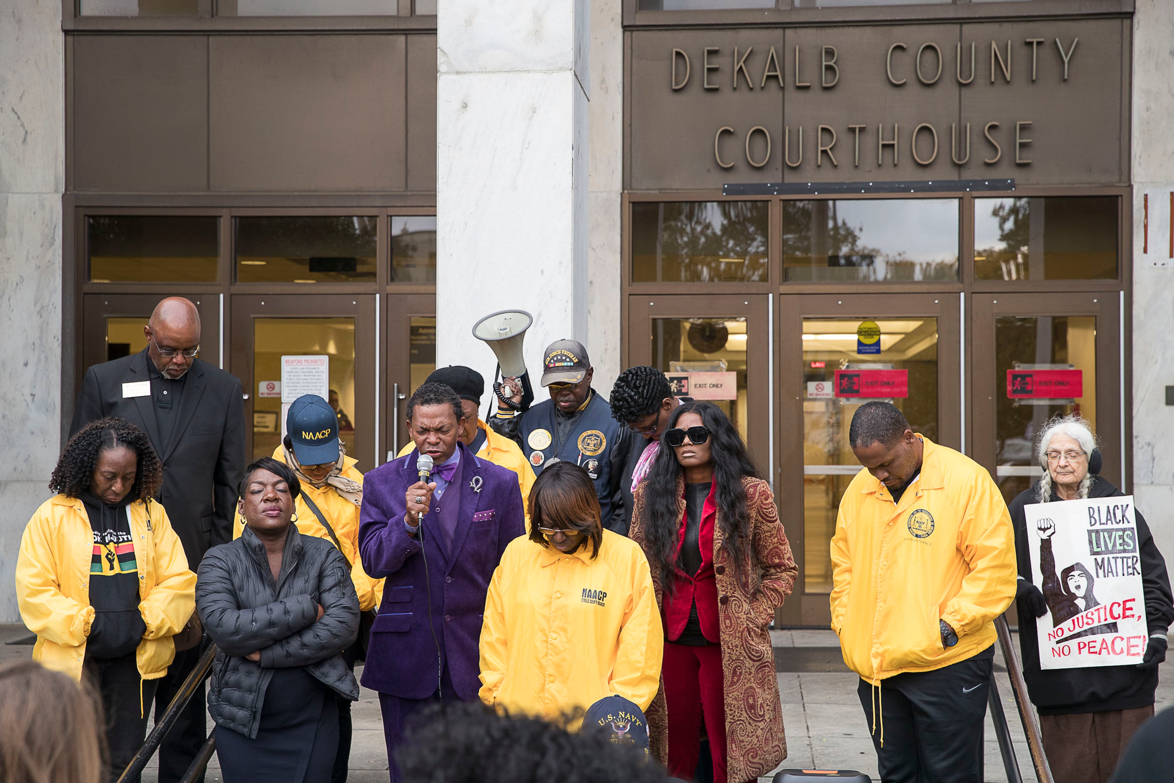10/31/2019 -- Decatur, Georgia -- Rev. Steven Dial (holding microphone) of Rainbow Park Baptist Church prays for the DeKalb County police department during a DeKalb County NAACP prayer vigil outside of the DeKalb County courthouse, Wednesday, October 31, 2019. People gathered outside of the courthouse to pray for the family of Anthony Hill, the DeKalb County justice system and the DeKalb County Police Department. (Alyssa Pointer/Atlanta Journal Constitution)