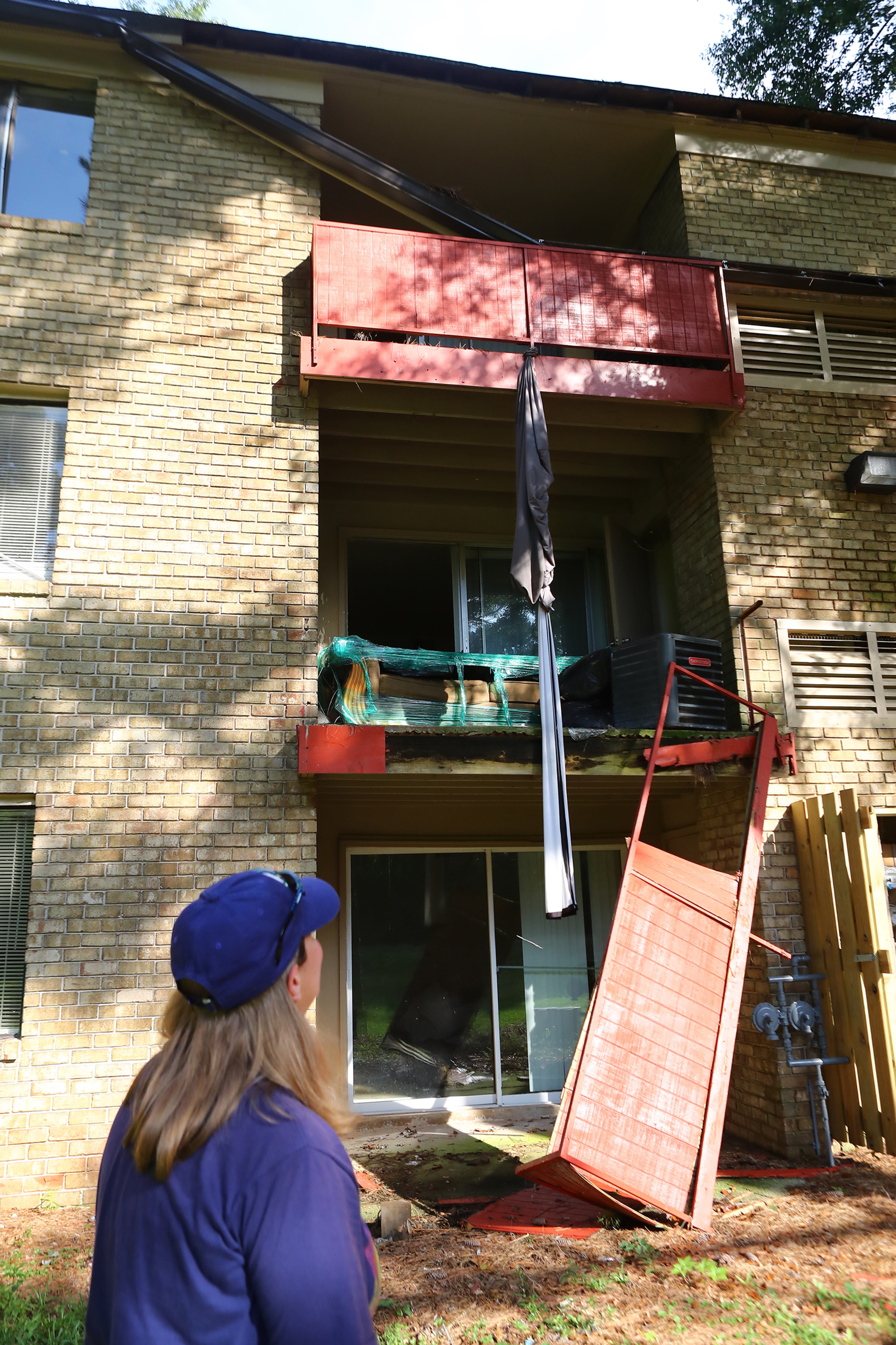 Kristy Neff walks behind her apartment building where porches and gutters are collapsing and windows shattered awaiting repair in The Village at Kensington on Sept. 6, 2022, in Decatur. “Curtis Compton / Curtis Compton@ajc.com