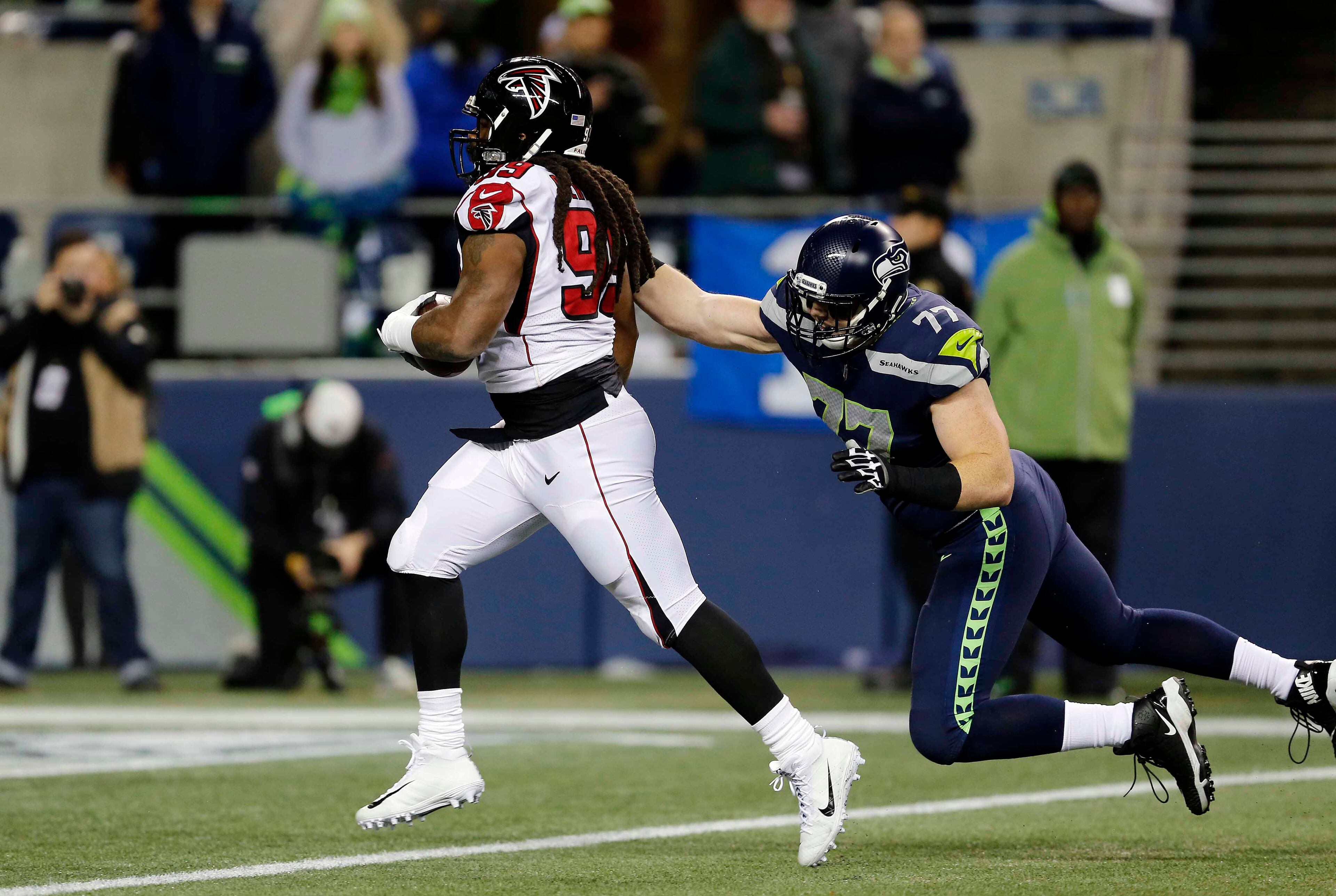 Atlanta Falcons' Adrian Clayborn (99) runs in for a touchdown as Seattle Seahawks' Ethan Pocic gives chase after Clayborn scooped up a Seahawks' fumble in the first half of an NFL football game, Monday, Nov. 20, 2017, in Seattle. (AP Photo/Stephen Brashear)