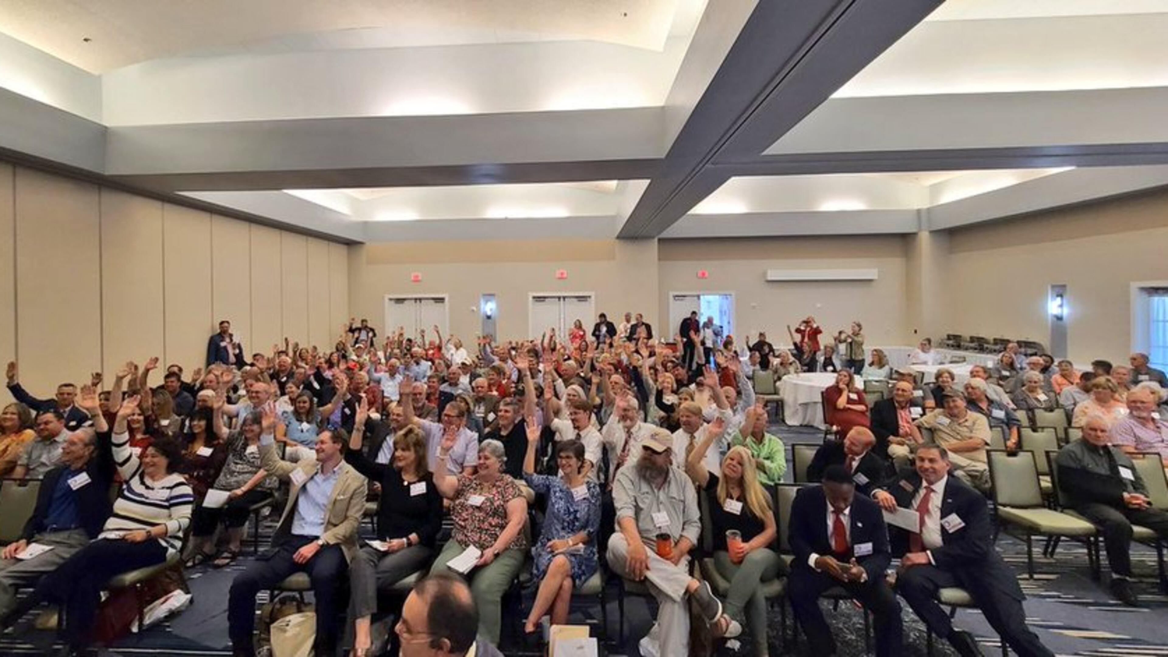 Newcomers to Georgia Republican meetings raise their hands during the 1st District GOP convention on May 15, 2021.