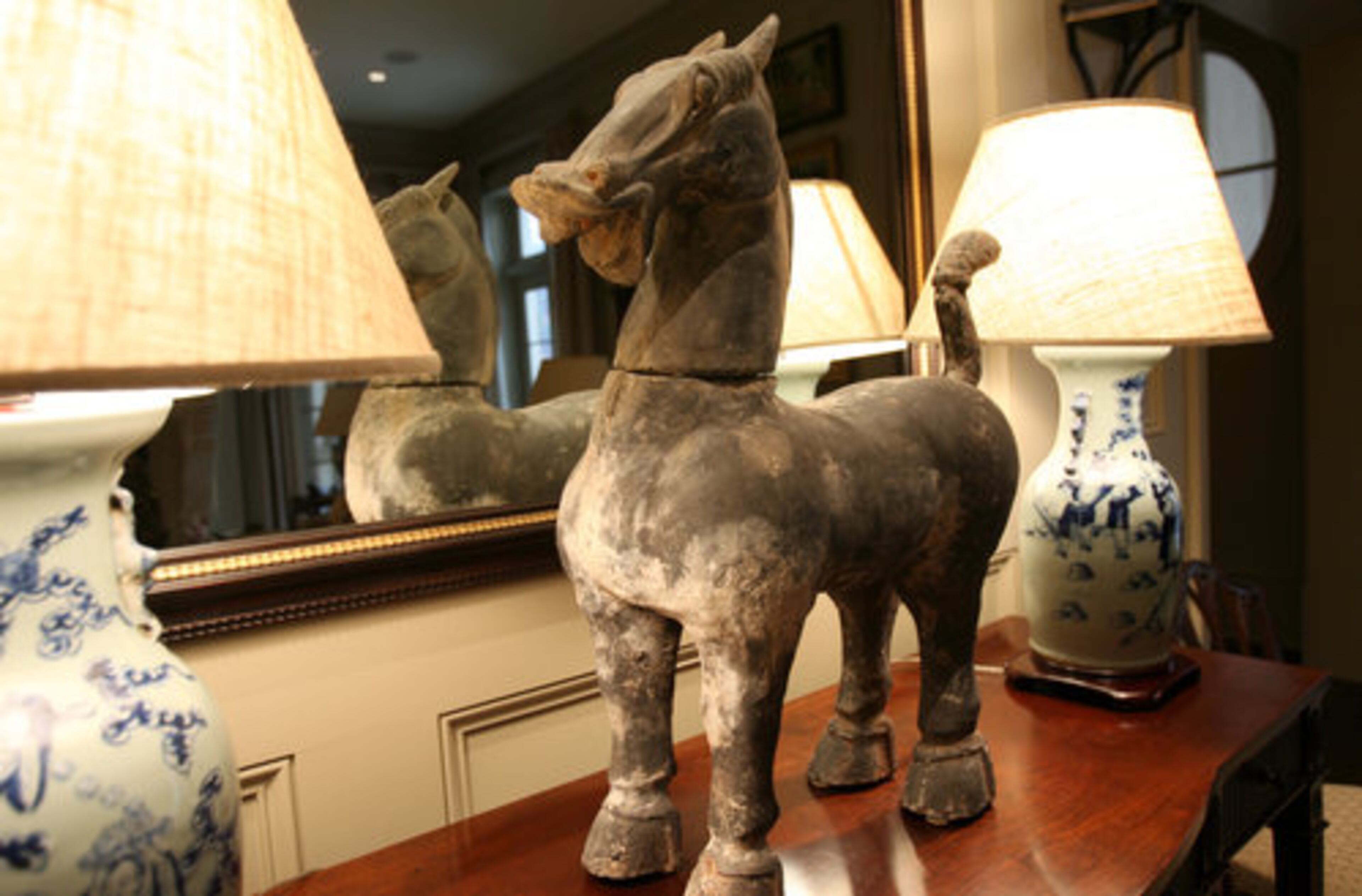 An Oriental horse stands on an antique English server table in the family room. The owners' fine collection of pieces dates primarily from China's Song dynasty, A.D. 960-1279.