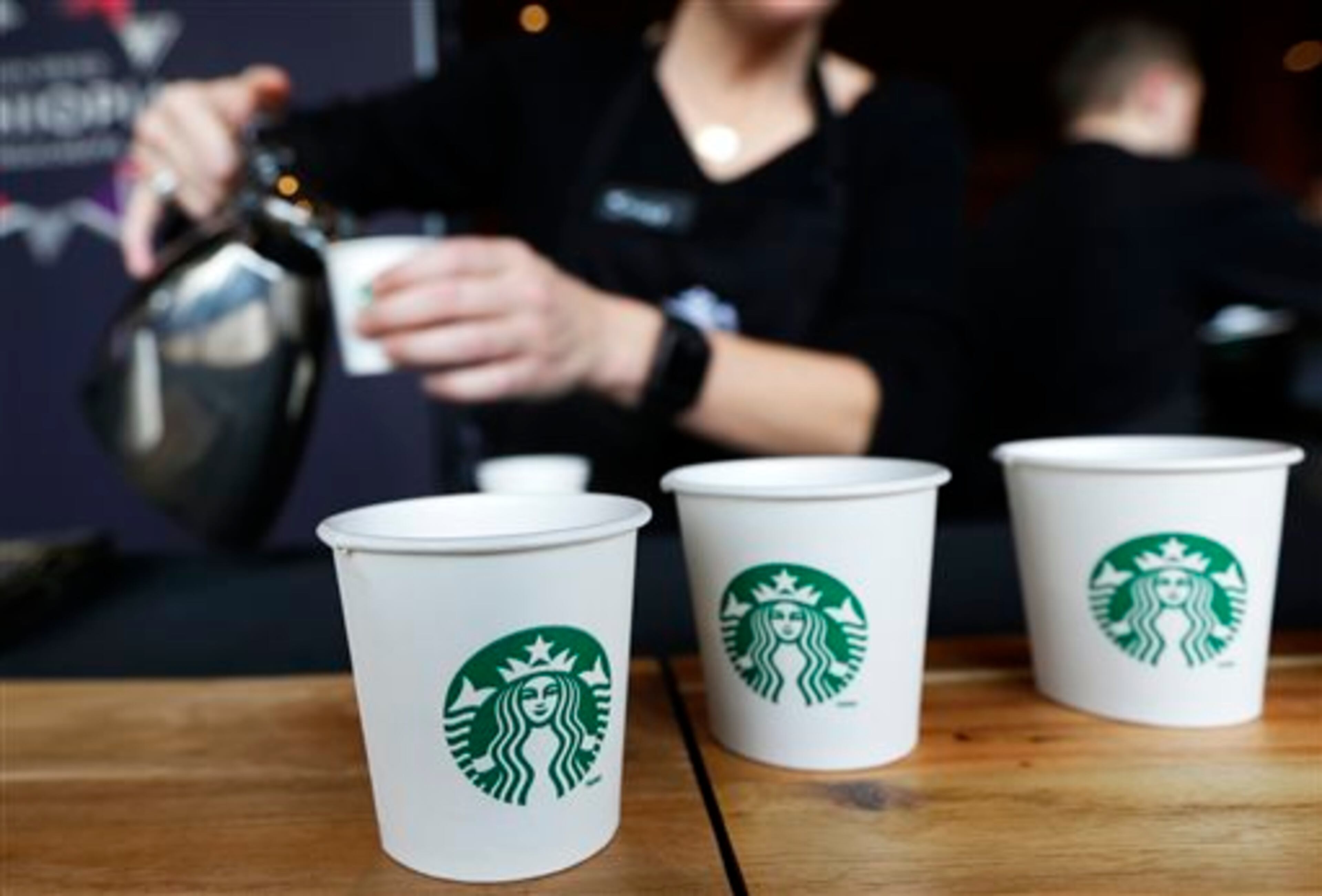 Sandy Roberts, Starbucks strategy manager for global coffee engagement, pours samples of coffee for shareholders and other guests, Wednesday, March 19, 2014, at Starbucks' annual shareholders meeting in Seattle. (AP Photo/Ted S. Warren)