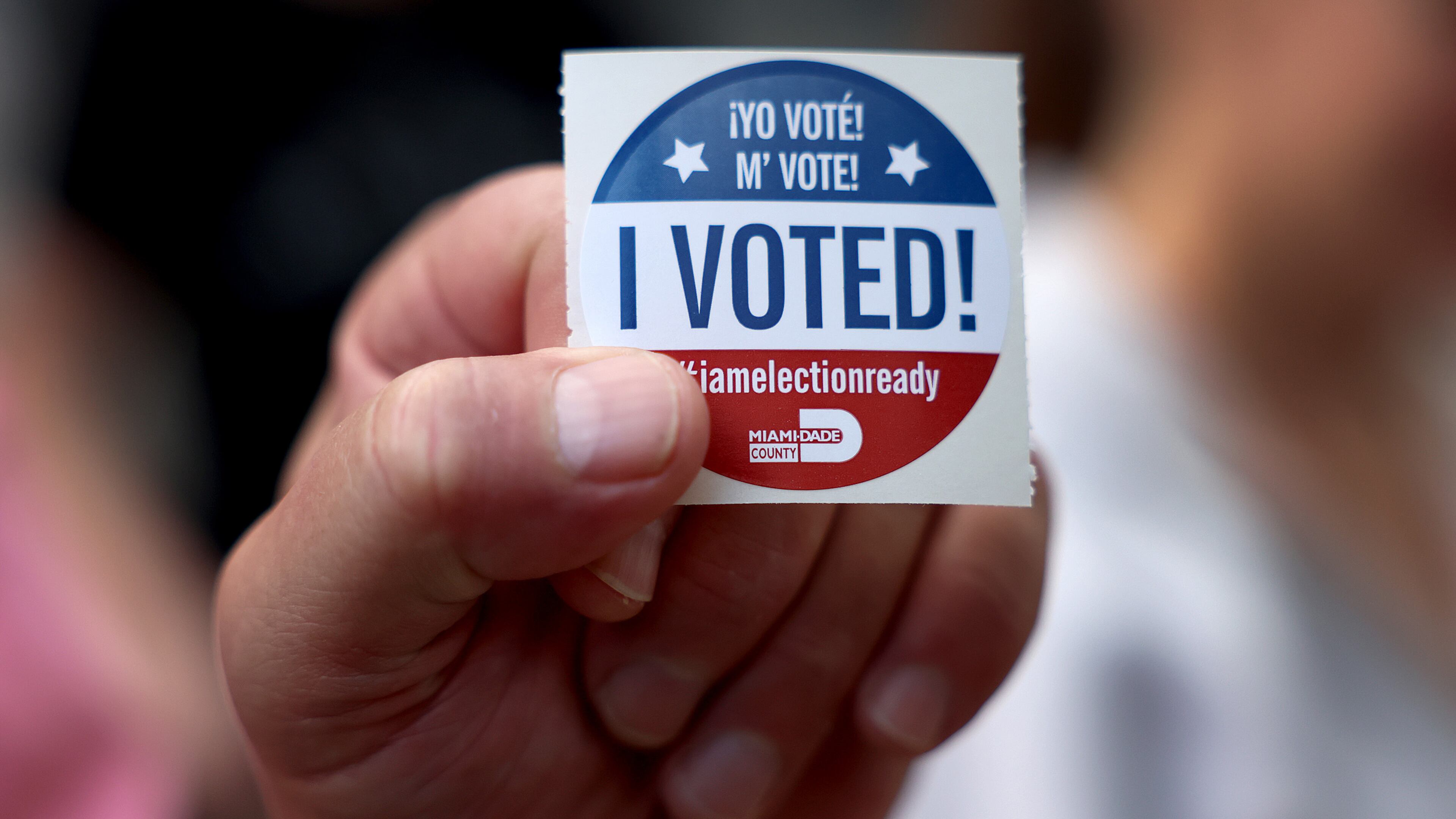 A voter shows off their, 'I Voted", sticker after casting their ballot at a polling station on Nov. 8, 2022, in Miami. (Joe Raedle/Getty Images/TNS)