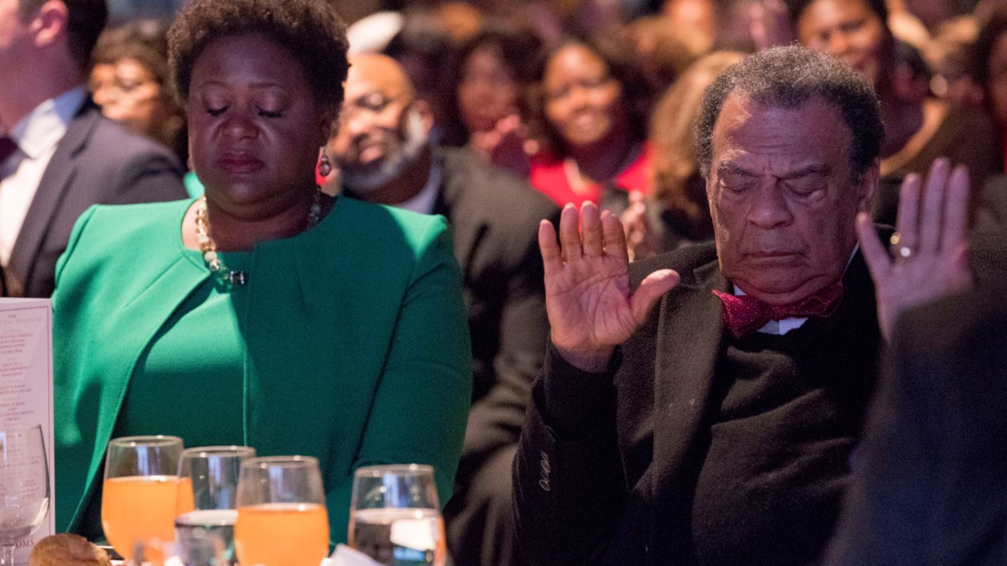Fomer Atlanta mayor Andrew Young and City Council President-elect Felicia Moore bow their heads at a pre-inaugural event last January. ALYSSA POINTER/ALYSSA.POINTER@AJC.COM