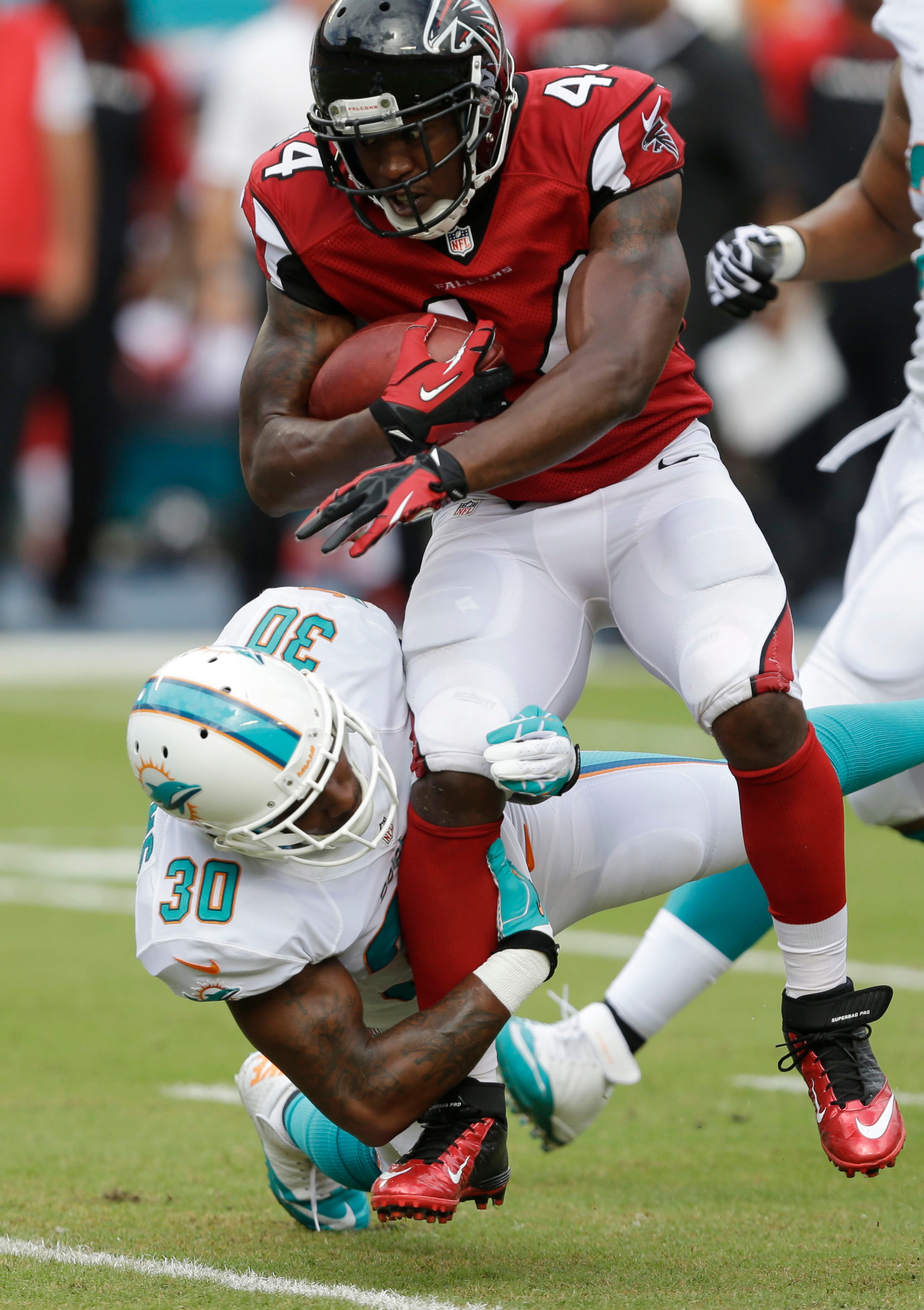 Atlanta Falcons fullback Jason Snelling (44) is tackled by Miami Dolphins strong safety Chris Clemons (30) during the first half.