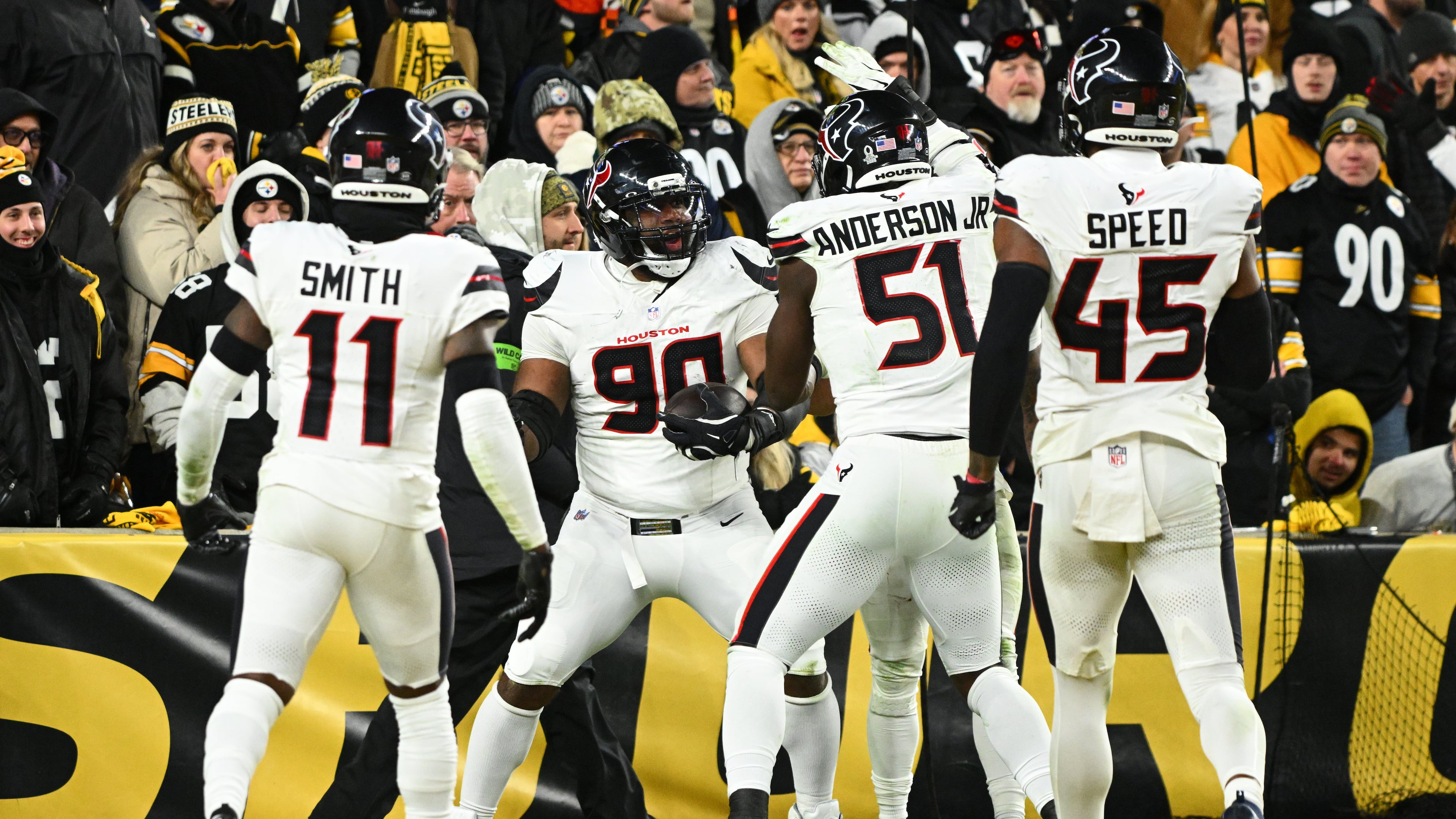 Houston Texans defensive tackle Sheldon Rankins (90) celebrates with cornerback Tremon Smith (11), defensive end Will Anderson Jr. (51) and linebacker E.J. Speed (45) after a touchdown during the second half of an NFL wild-card playoff football game against the Pittsburgh Steelers, Monday, Jan. 12, 2026, in Pittsburgh. (AP Photo/Justin Berl)