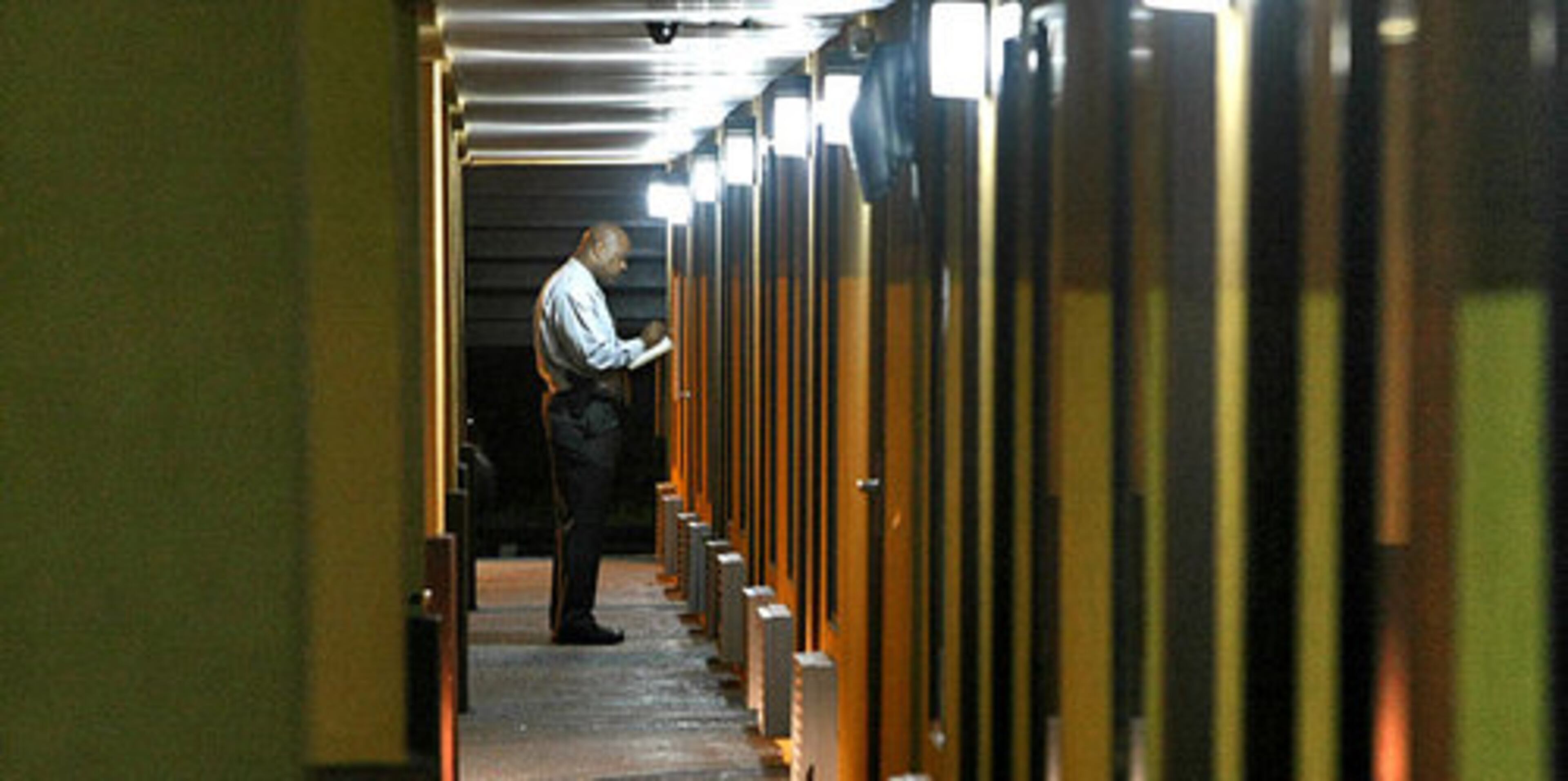 A DeKalb County police investigator takes notes outside the doorway of a room on the first floor of the Friendship Inn on Glenwood Road near I-285 Thursday where a double shooting and homicide occurred. One person is reported to be dead and the second was taken to Grady Memorial Hospital. Detectives and Crime scene personnel were focusing on a room on the first floor of the building.