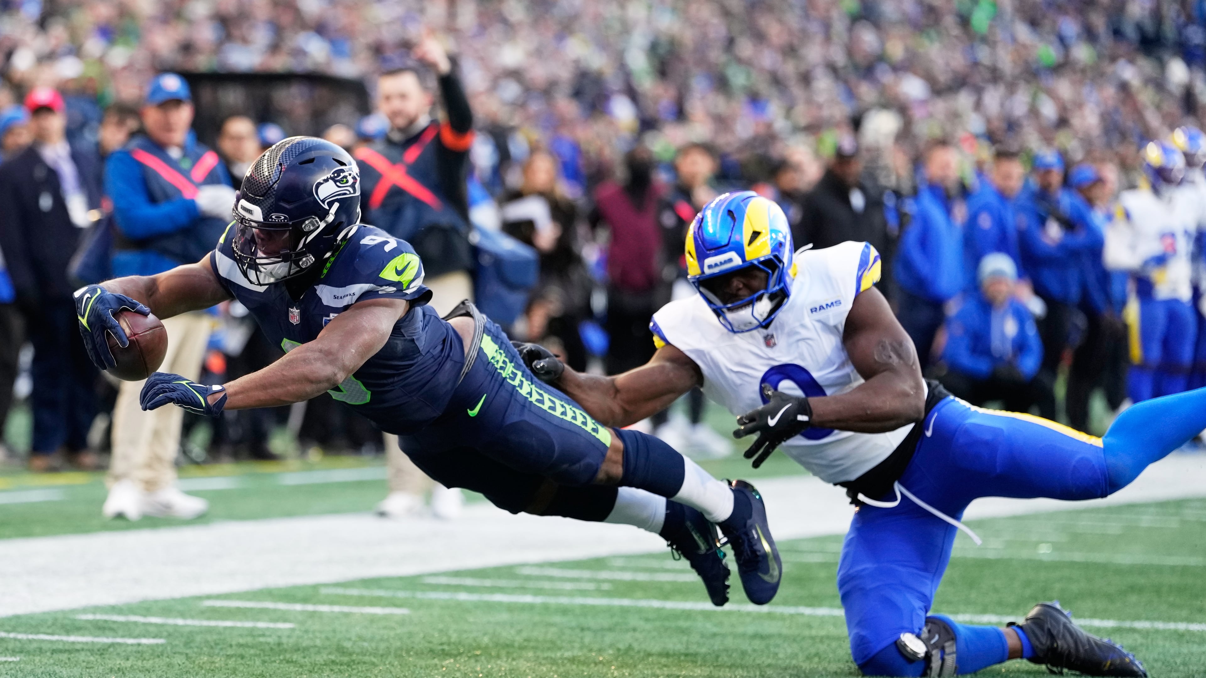 Seattle Seahawks running back Kenneth Walker III (9) scores a touchdown past Los Angeles Rams linebacker Byron Young (0) during the first half of the NFC Championship NFL football game Sunday, Jan. 25, 2026, in Seattle. (AP Photo/Stephen Brashear)