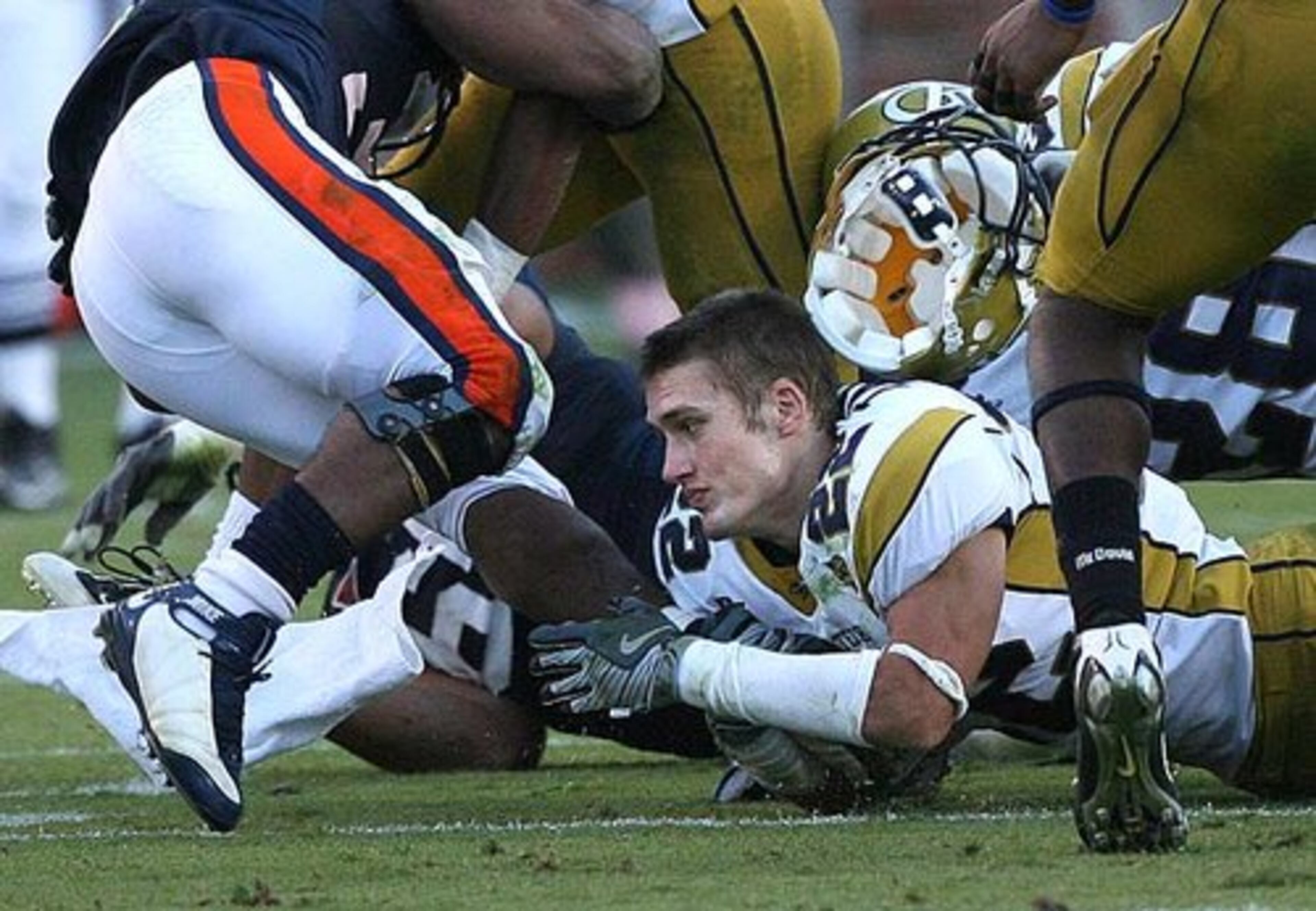 Georiga Tech's Cooper Taylor loses his helment as he assists in a tackle.