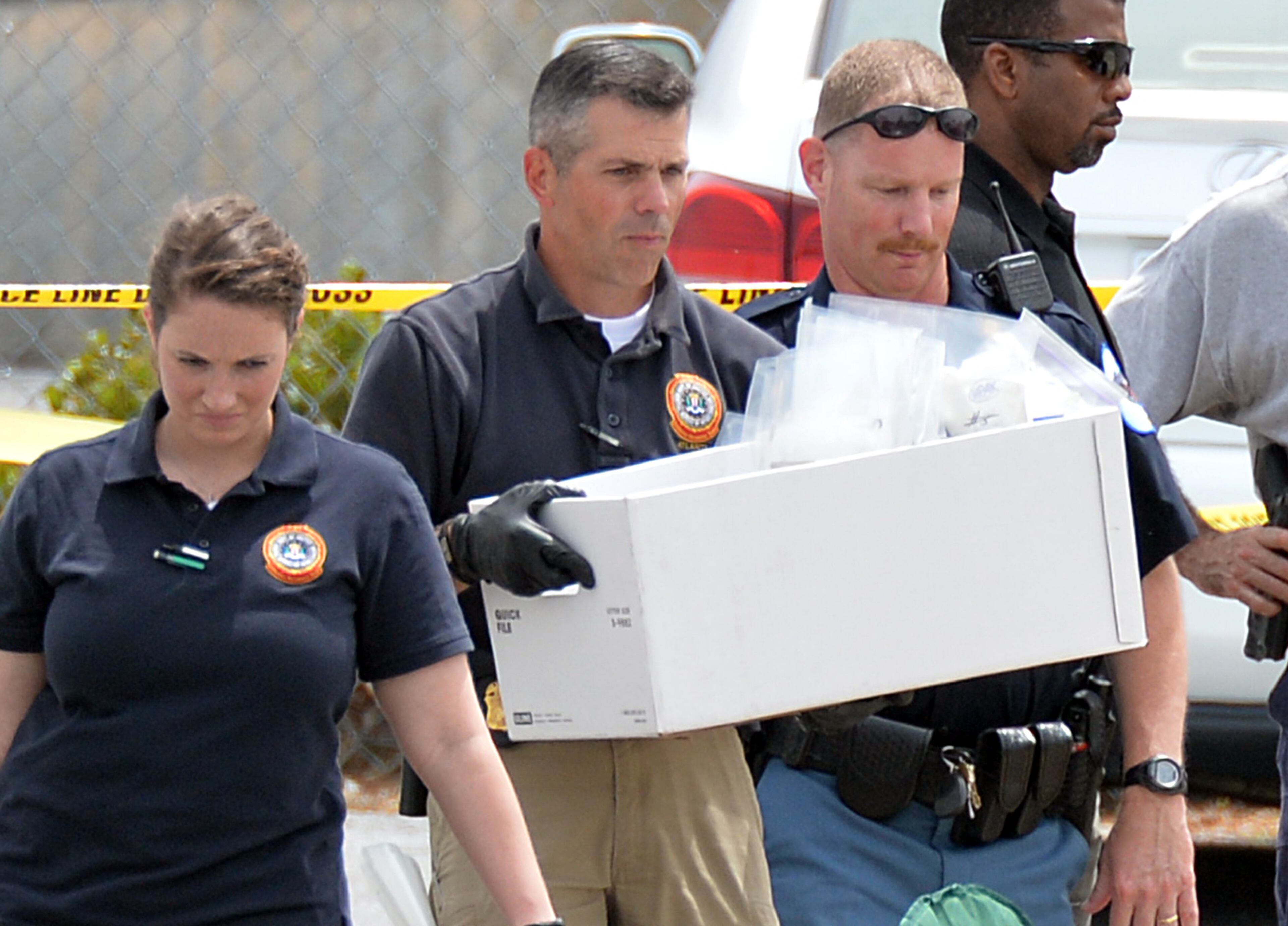 Authorities bring out evidence from the scene of the early morning workplace shooting at a FedEx facility in Kennesaw on Tuesday, April 29, 2014. HYOSUB SHIN / HSHIN@AJC.COM