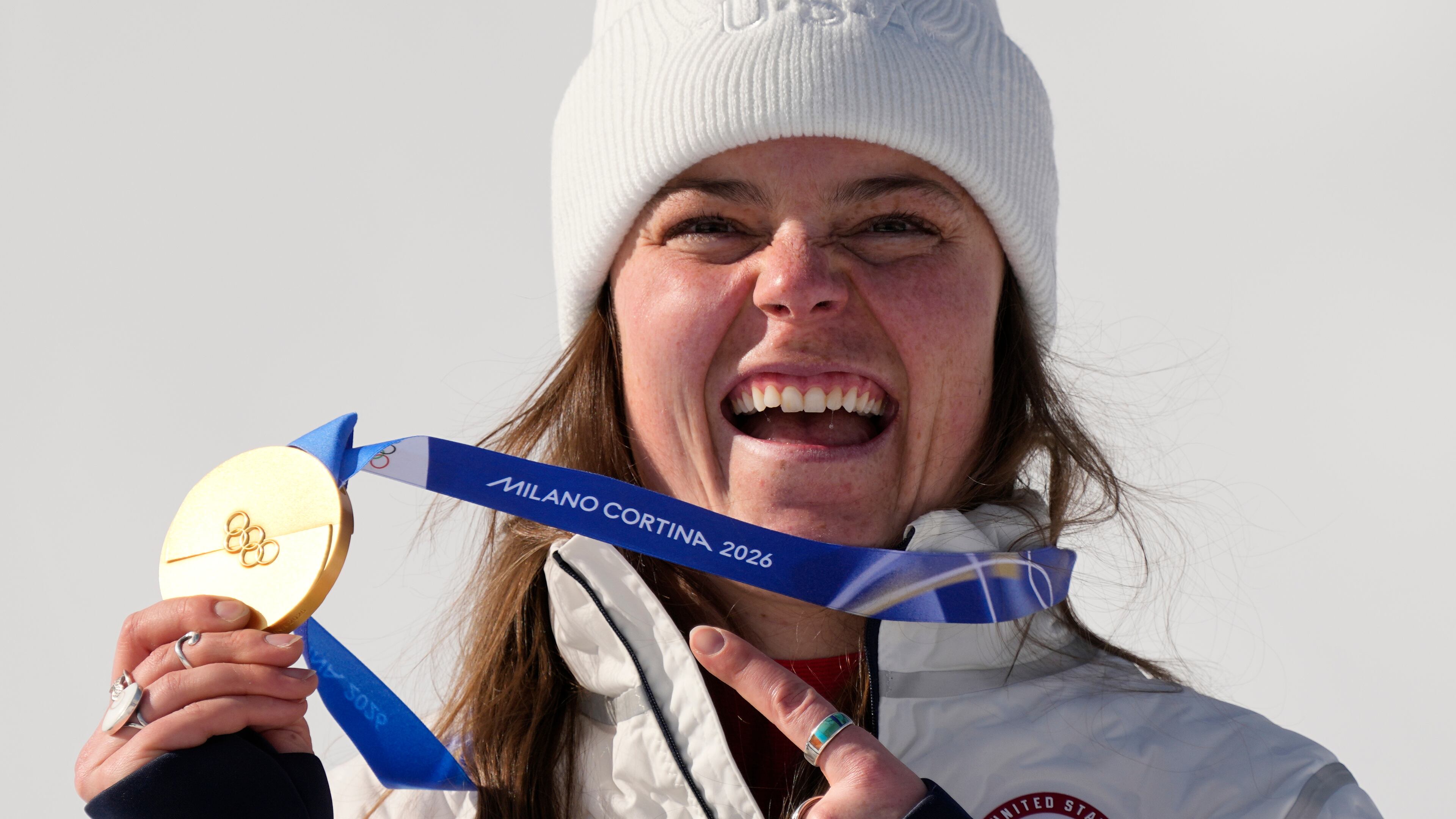United States' Breezy Johnson shows her gold medal in the alpine ski women's downhill race, at the 2026 Winter Olympics, in Cortina d'Ampezzo, Italy, Sunday, Feb. 8, 2026. (AP Photo/Andy Wong)