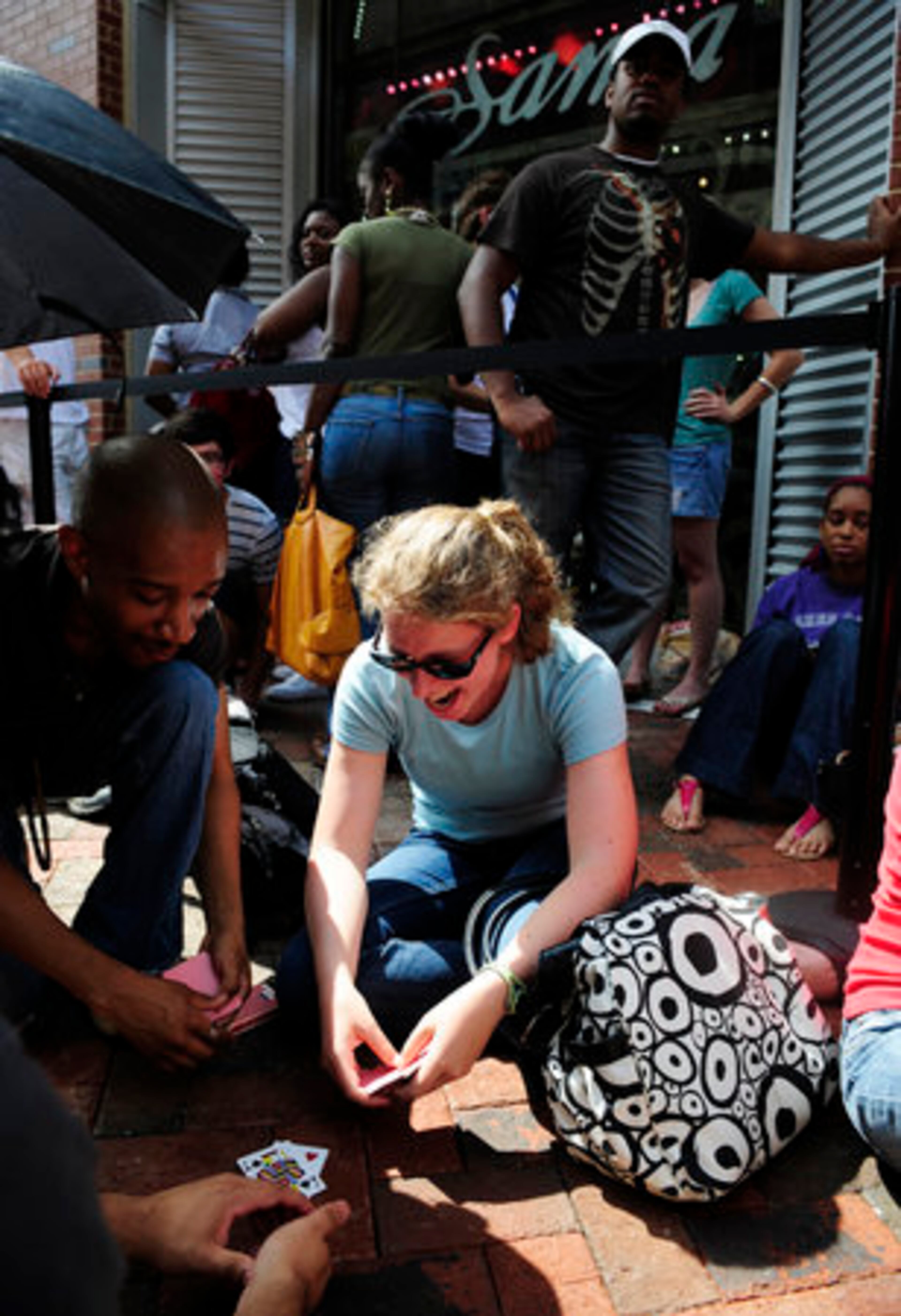 Many people who were in line first spent the night in front of the store. Devon Green (left), 22, plays cards with Laura Rusiecki outside the second H&M store.
