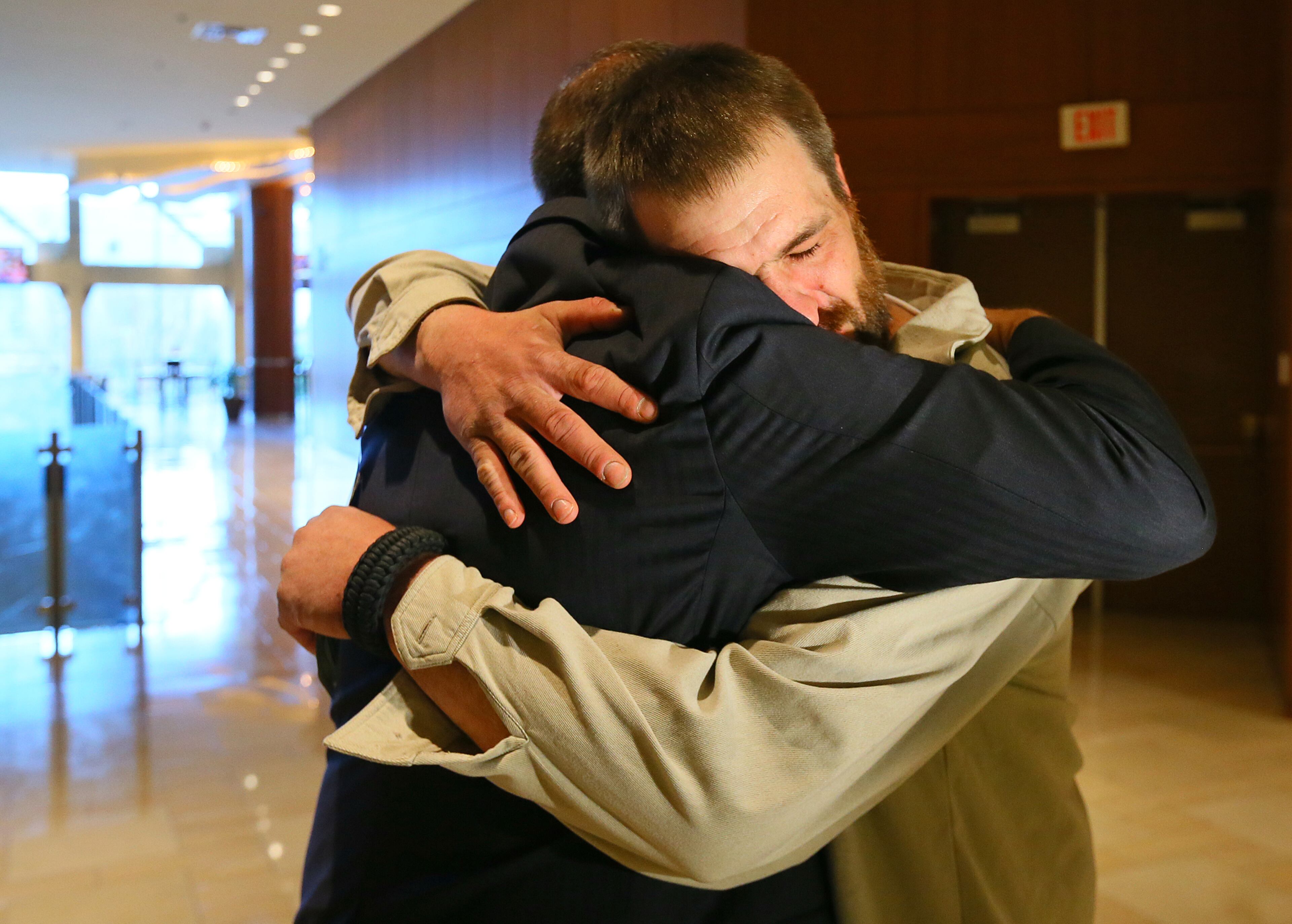 Joel Hartman, the "Homeless Hero" who returned a woman's wallet he found digging through trash hoping to find someone's leftover food, hugs Omni Hotel at CNN Center general manager Scott Stuckey after Stuckey presented him with some gifts from well-wishers that included a gift card to Publix, a note with $80, and a card with $500 on Nov. 25, 2013, in Atlanta.