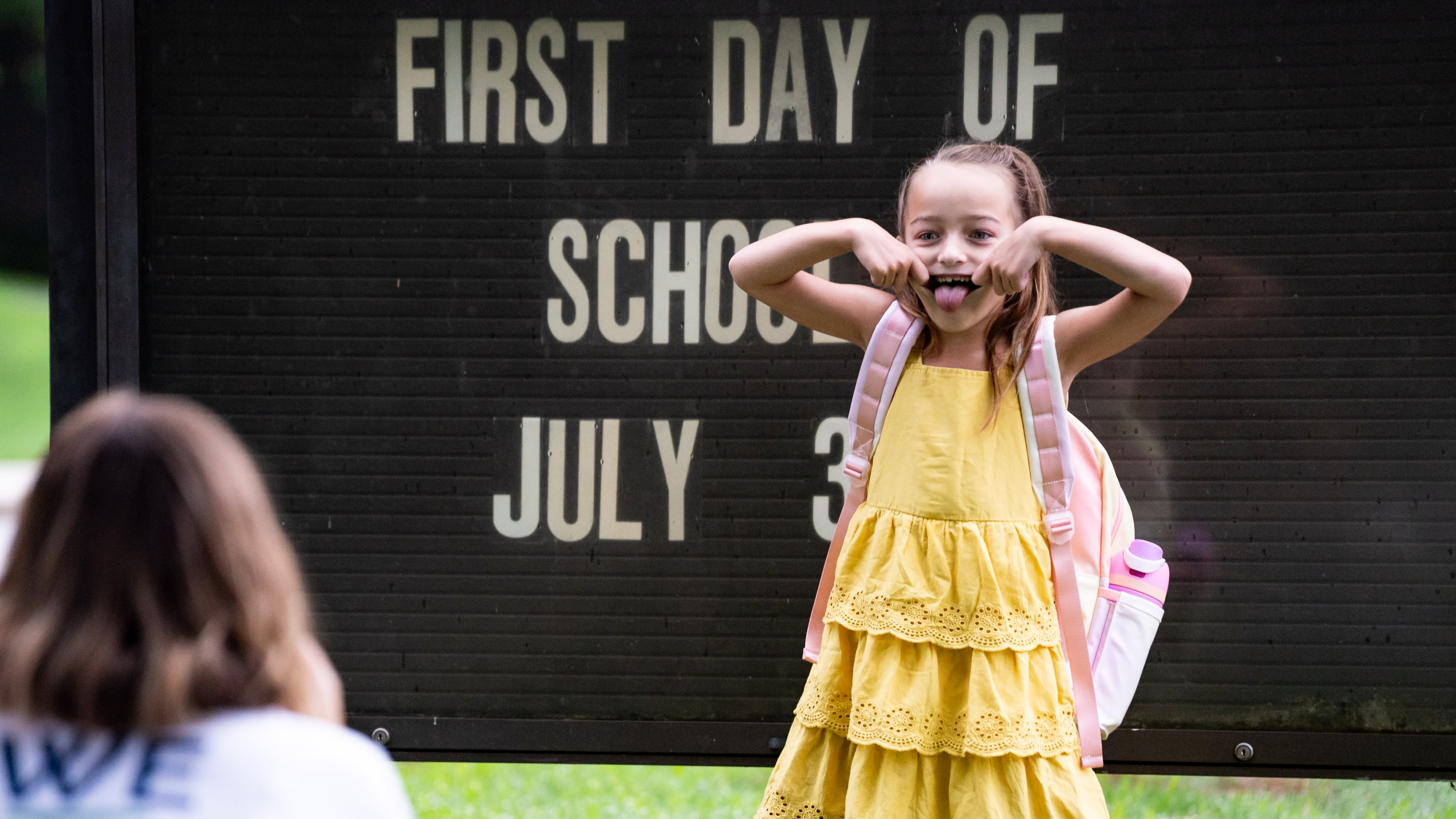 Corbitt VanDuzer, 6, strikes a pose for her mother, teacher Kathryn VanDuzer, before her first day of first grade at Glennwood Elementary School in Decatur, Ga., on Tuesday, July 30, 2024. (Seeger Gray/AJC)