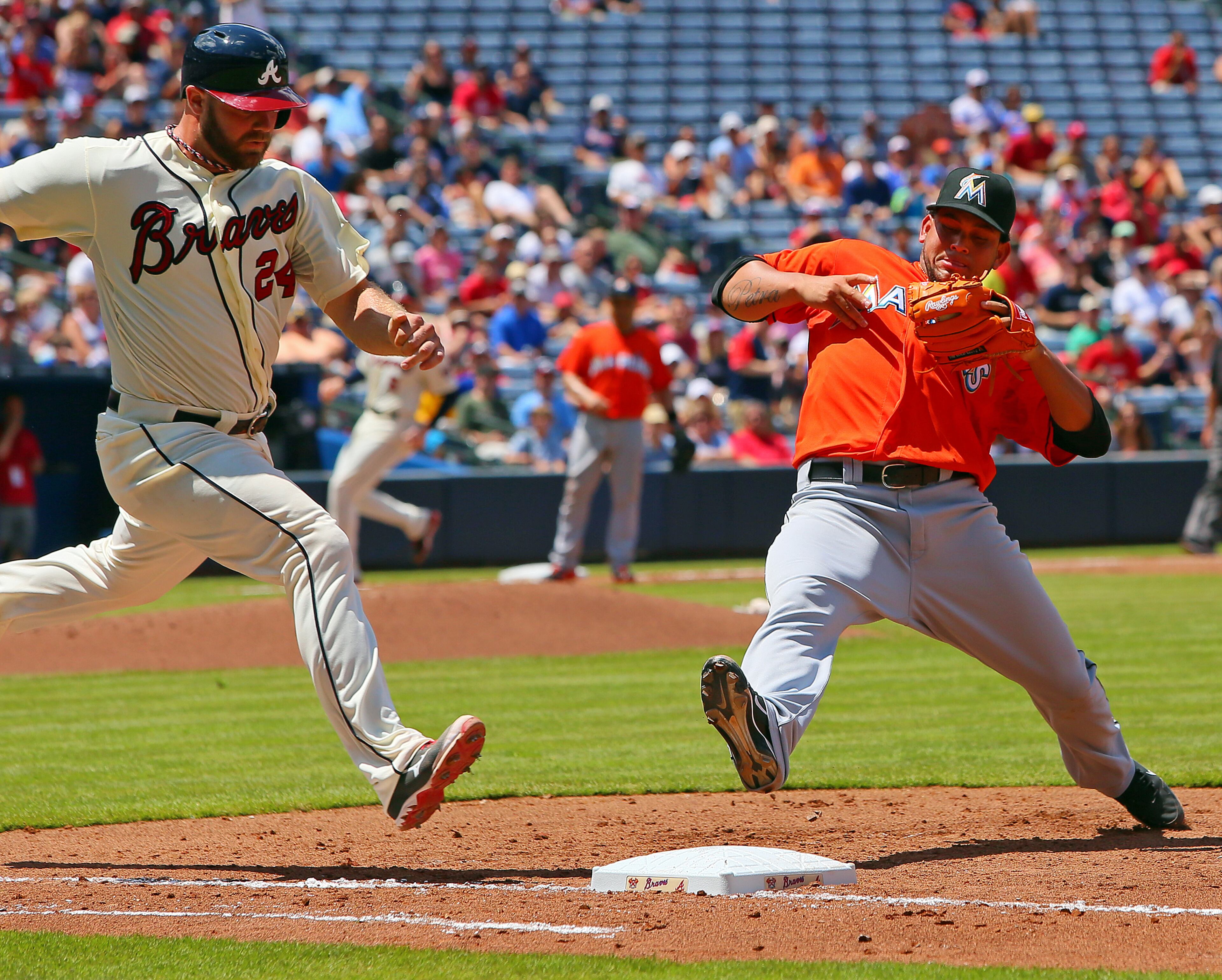 Evan Gattis wins the foot race with Marlins pitcher Henderson Alvarez reaching first base safely on a ground ball during the 4th inning.