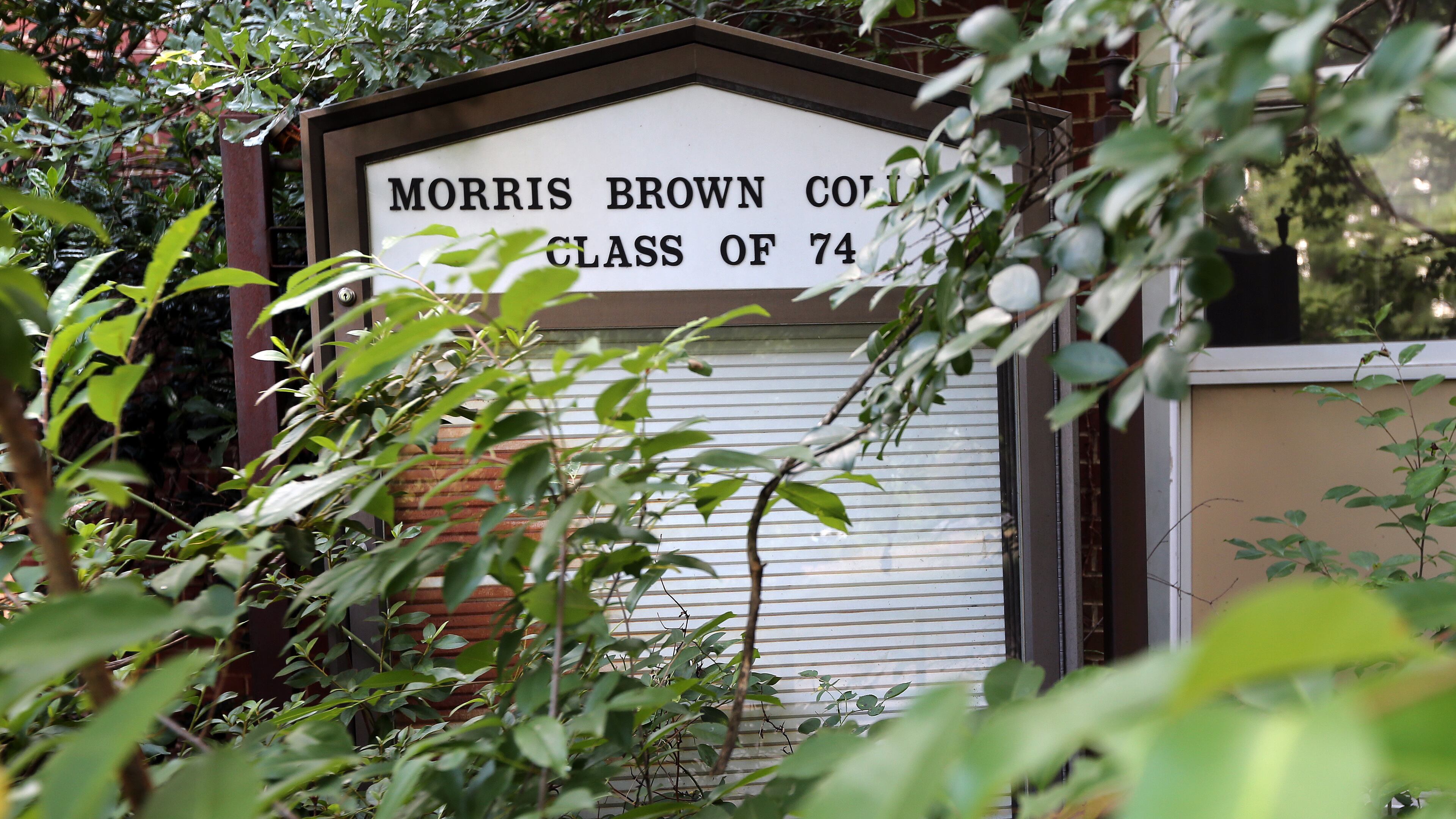 A building sign on Morris Brown College's campus is barely visible Thursday afternoon June 12, 2014. The college, in Southwest Atlanta, is currently in bankruptcy. BEN GRAY / BGRAY@AJC.COM