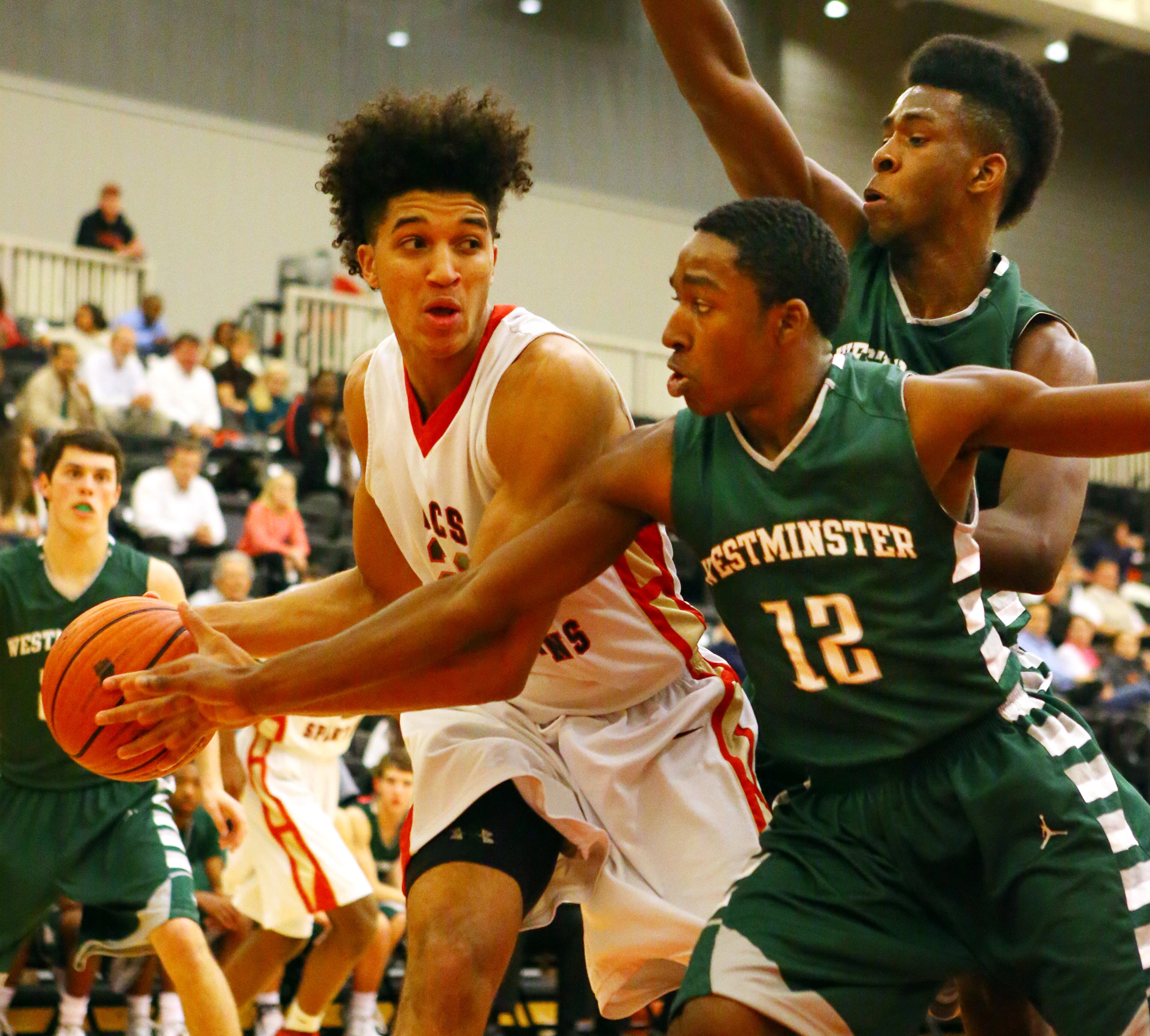 GAC Spartans Isaiah Wilkins looks to pass around Westminster Wildcats defender Marquavious Strozier during the first half of their high school basketball game at Greater Atlanta Christian High School on Tuesday, Jan. 14, 2014, in Norcross.
