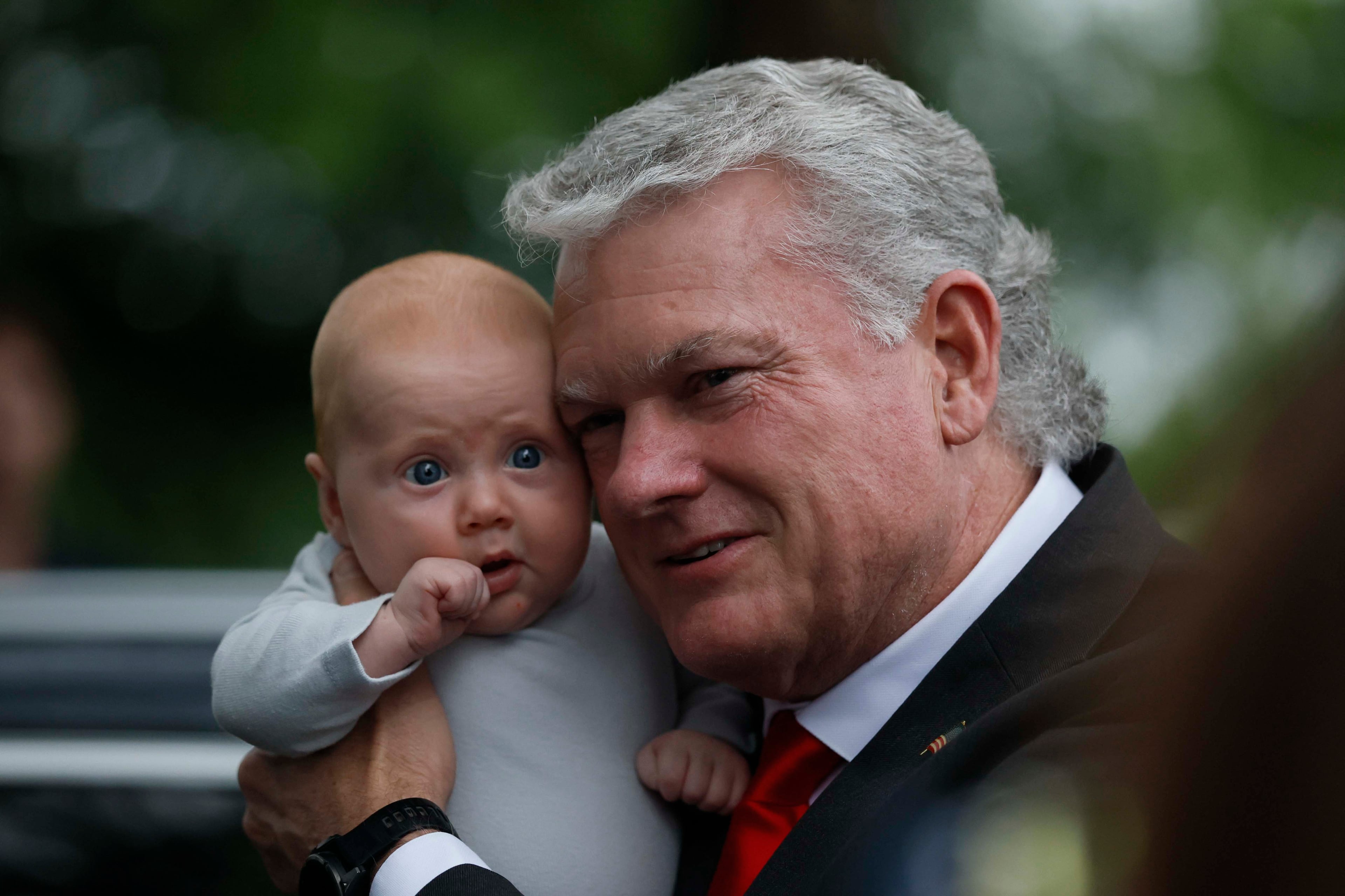 U.S. Rep. Mike Collins embraces his grandson as he arrives at the runoff election watch party at Seven Oaks Manor in Jackson, Georgia, on Tuesday, June 16, 2026. (Miguel Martinez/AJC)