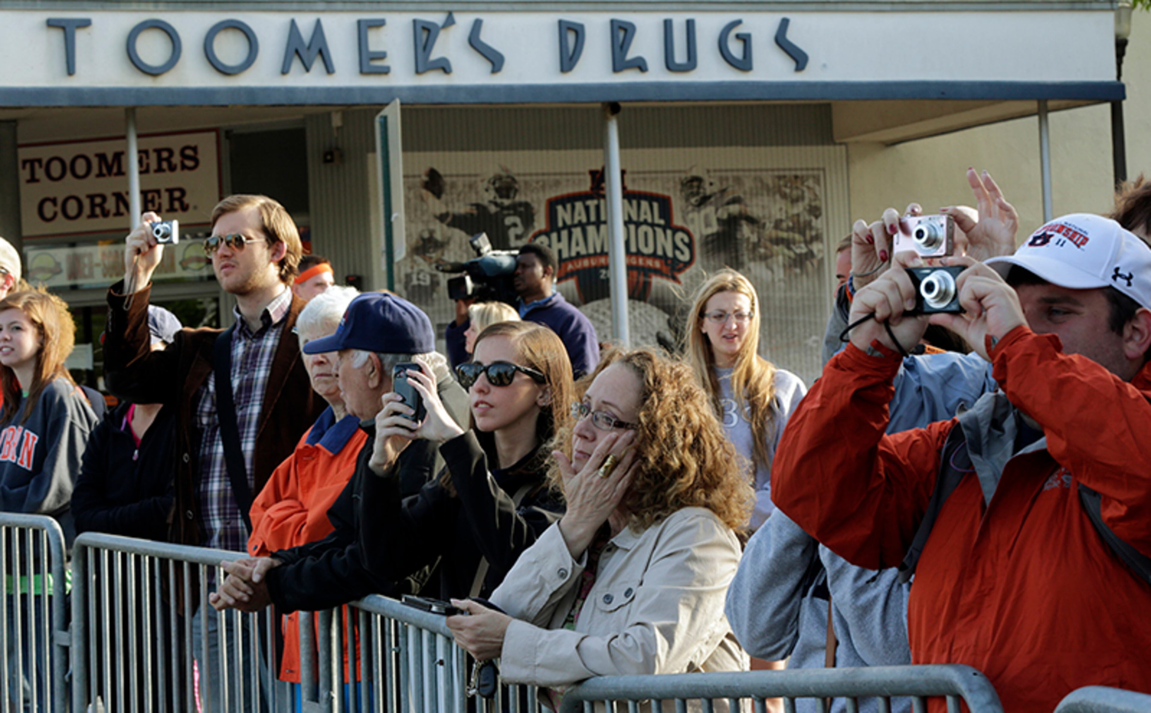 Auburn University employee Dinah Decker (center) wipes tears from eyes as she watches as city workers cut down the poisoned oak trees. Harvey Updyke Jr., an Alabama Crimson Tide fan, is serving a jail term after pleading guilty to spiking the oaks with a powerful herbicide, and experts say they can't be saved.