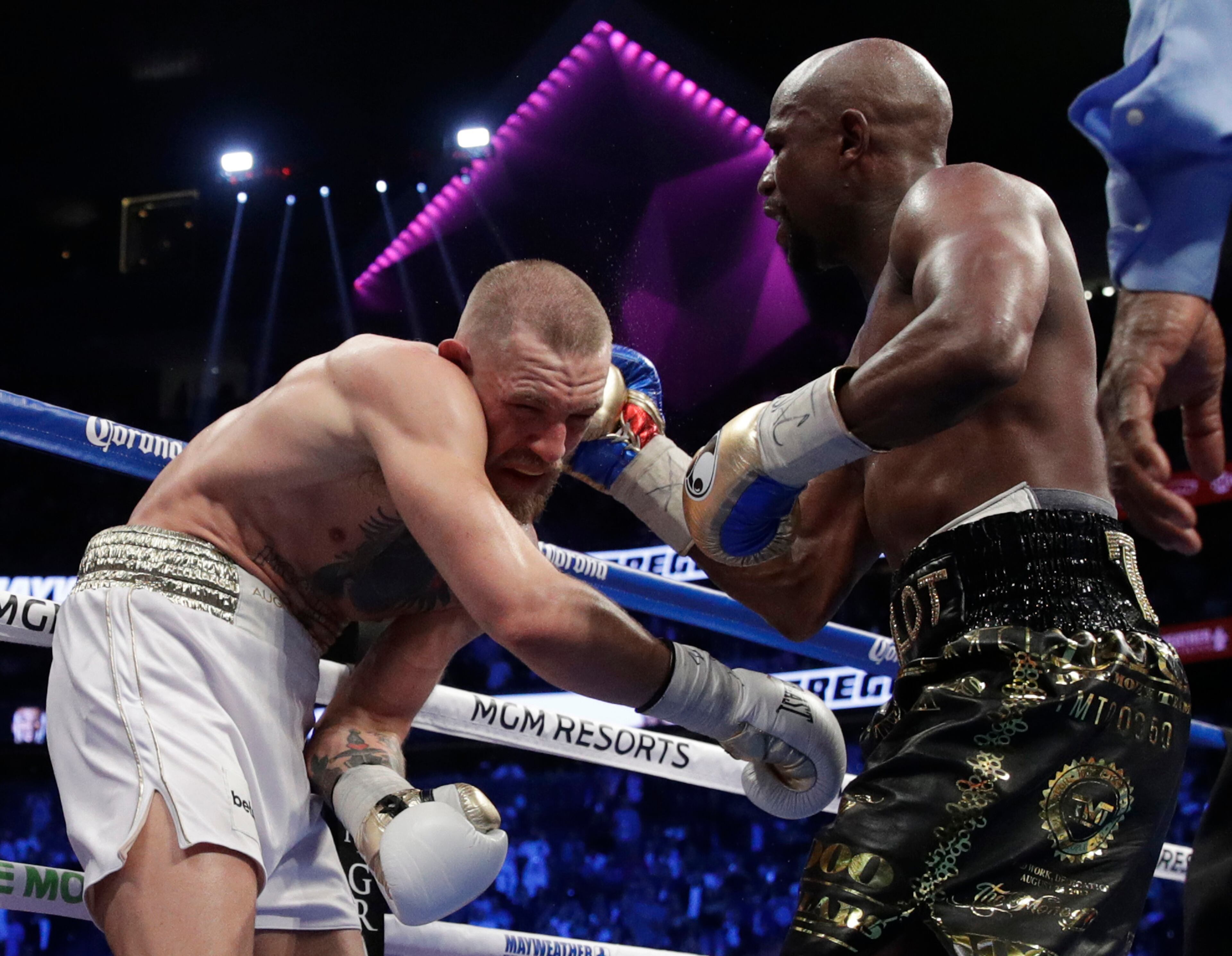 Floyd Mayweather Jr. hits Conor McGregor in a super welterweight boxing match Saturday, Aug. 26, 2017, in Las Vegas. (AP Photo/Isaac Brekken)