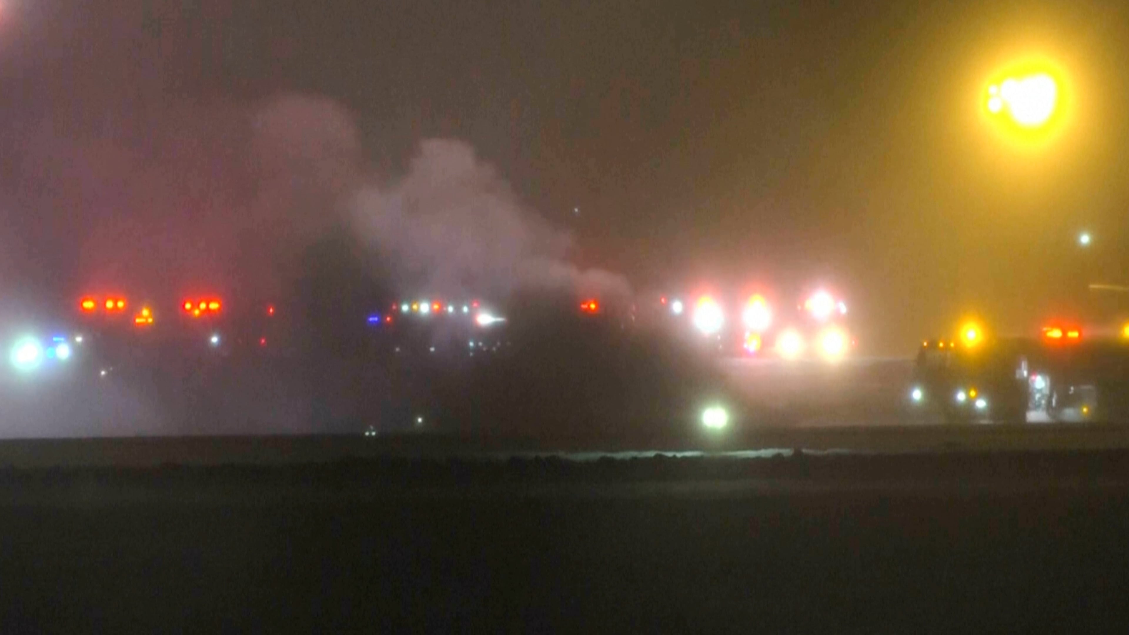This image taken from video provided by WABI television, emergency services work on a scene of the Bombardier Challenger 600 crash at the Bangor Airport in Maine, late Sunday, Jan. 25, 2026. (WABI via AP)